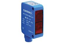 Ein blauer optoelektronischer Sensor mit einem roten Lichtfenster. Modellaufdruck: 'CONTRINEX'. Verwendet für Objektentfernungsmessung.