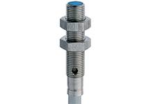 Ein zylindrischer Metallgegenstand, möglicherweise ein Sensor oder Schalter, mit einem blauen Ende und einem Gewinde mit zwei Muttern.
