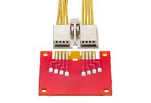 Rotes Leiterplattenmodul mit darauf verlöteten Chips und einem weißen Stecker mit mehreren gelben Kabeln.