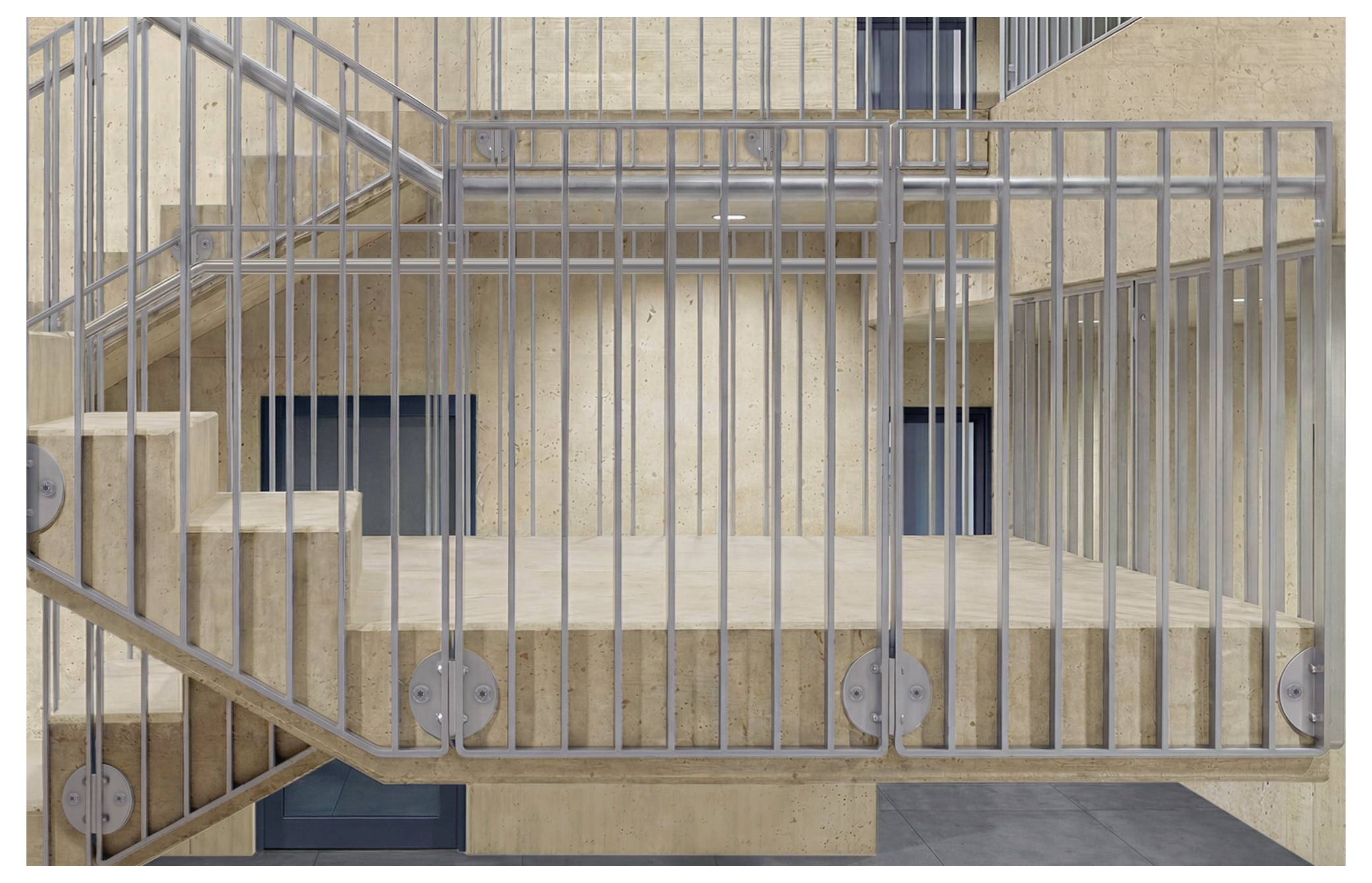 Eine moderne Innentreppe mit Metallgeländern und Holzstufen, umgeben von beigen Wänden und einigen Fenstern.