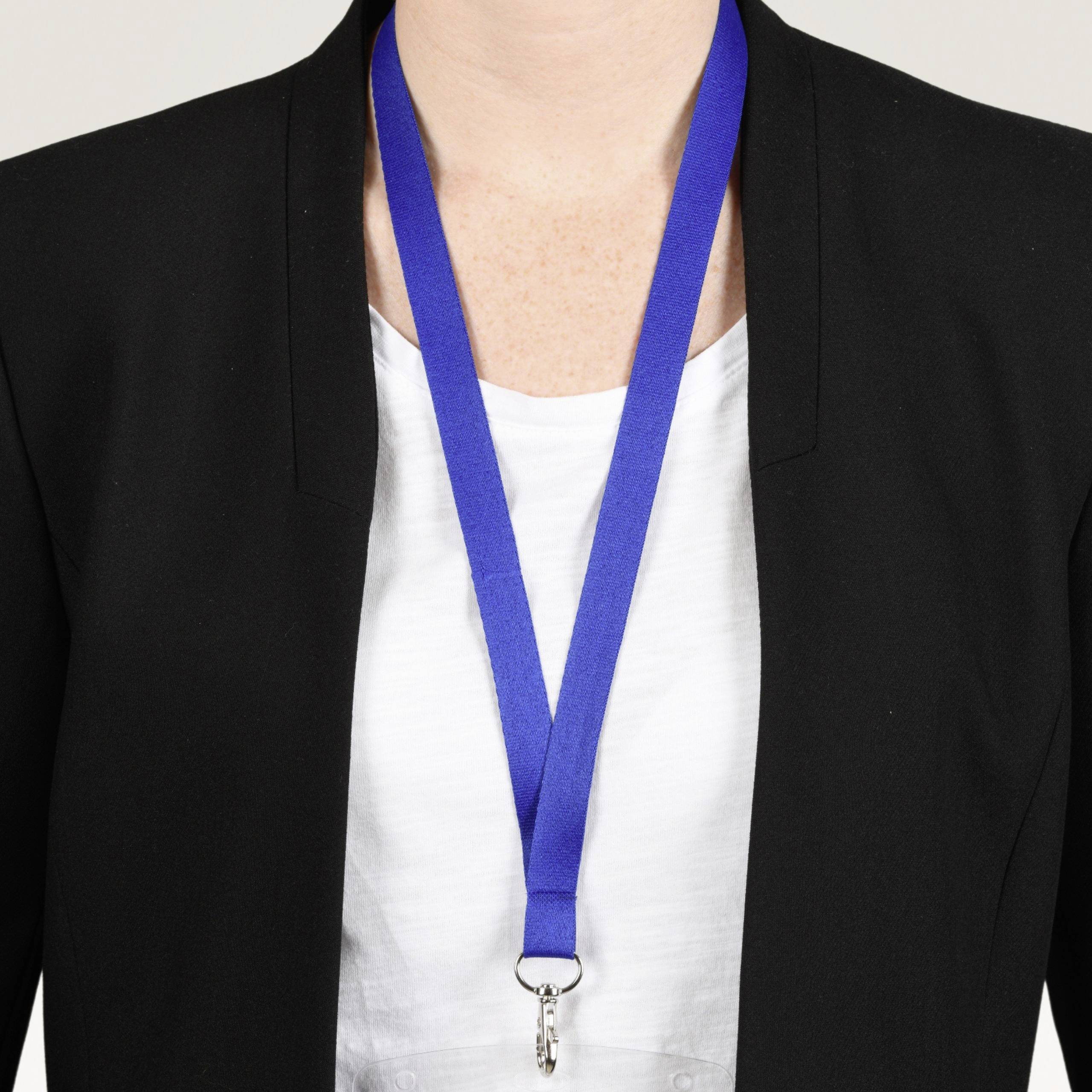 Person mit blauem Schlüsselband um den Hals, trägt einen schwarzen Blazer und ein weißes Oberteil.