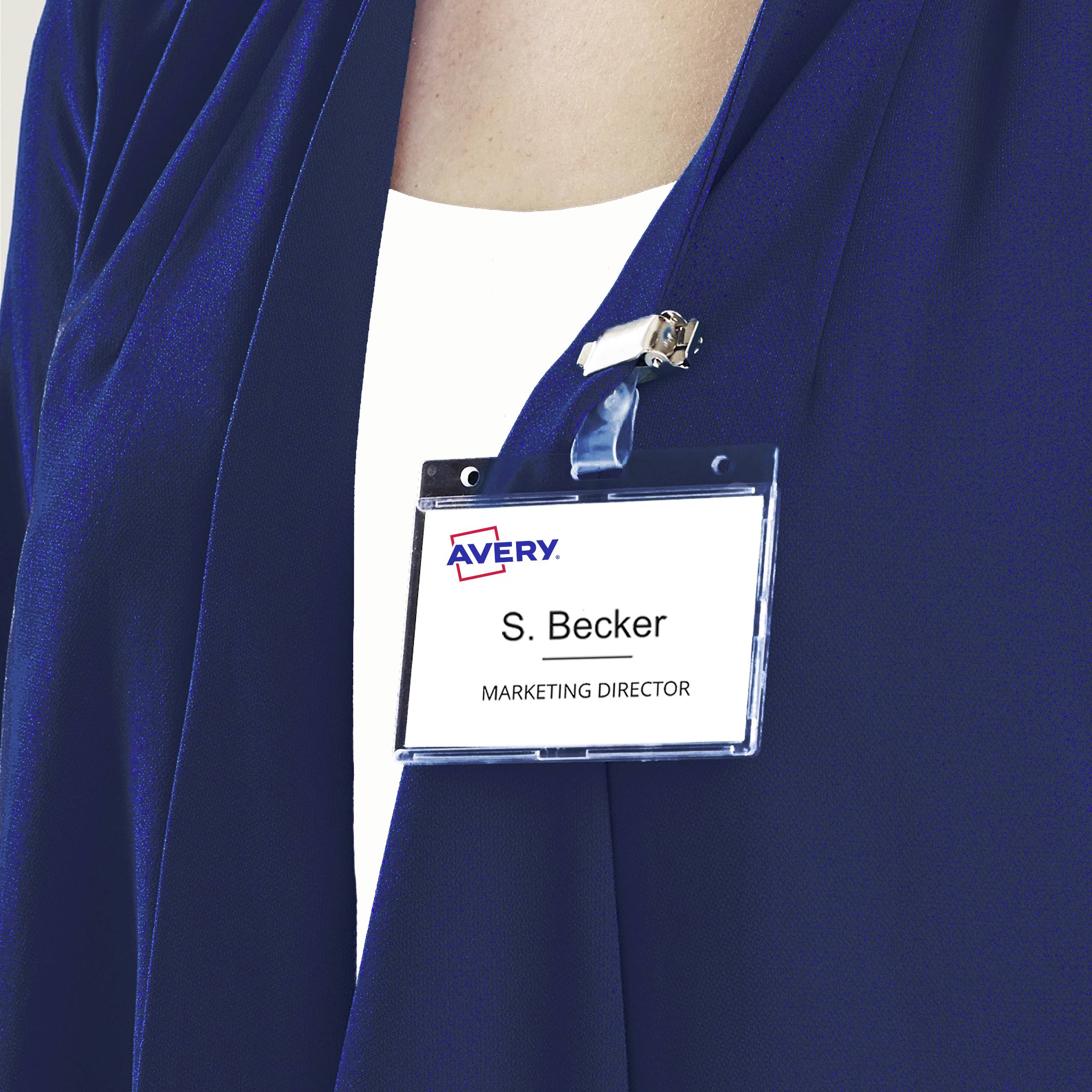 Eine Person trägt ein Namensschild mit der Aufschrift 'S. Becker, Marketing Director'. Das Schild ist an einem blauen Blazer befestigt.