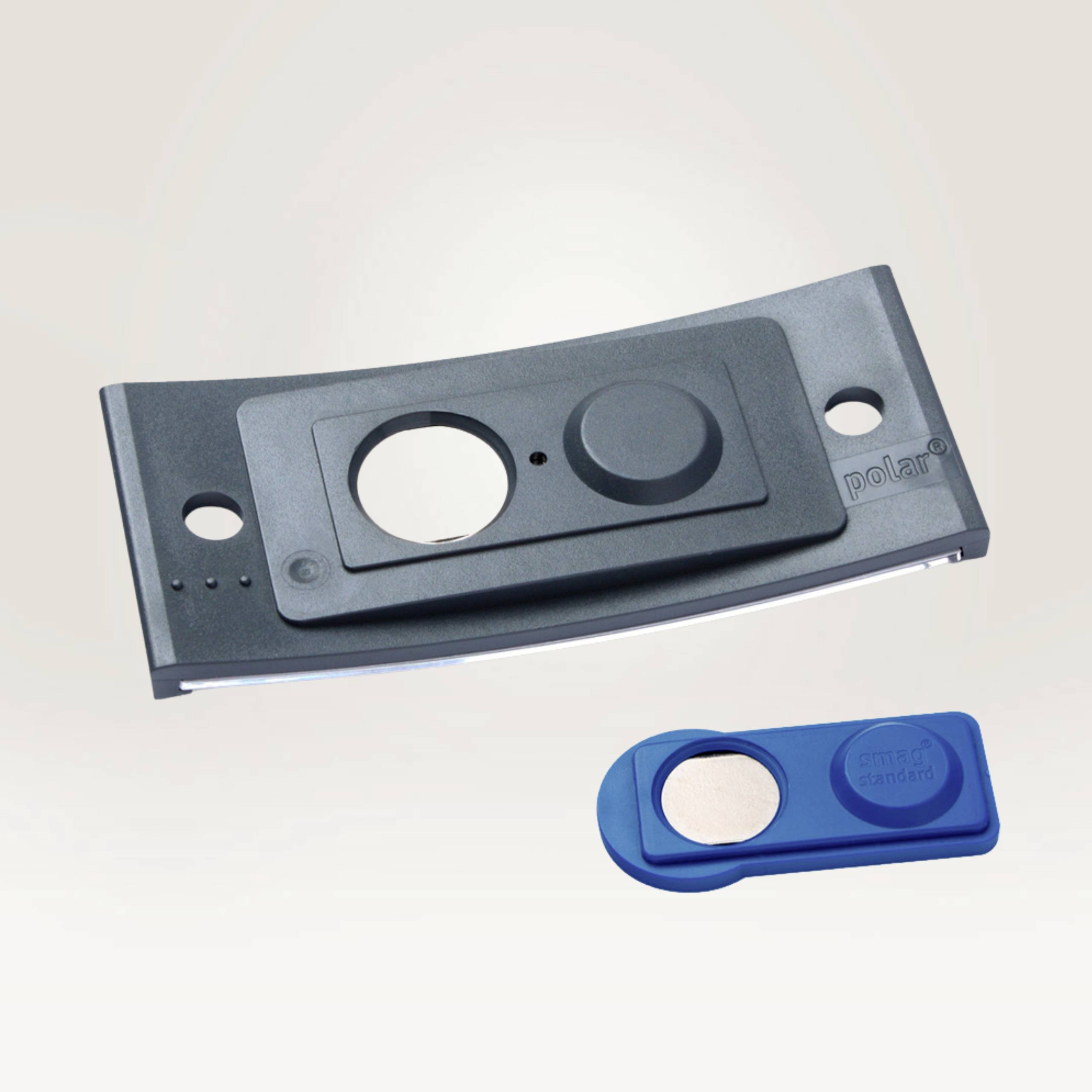 Ein schwarzes Plastikteil mit runden Öffnungen und ein blaues, abgerundetes Kunststoffstück mit einem silbernen Kreis darin.