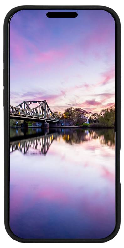Ein Smartphone zeigt einen Fluss bei Sonnenuntergang mit einer Brücke im Hintergrund. Der Himmel ist rosa und lila gefärbt.