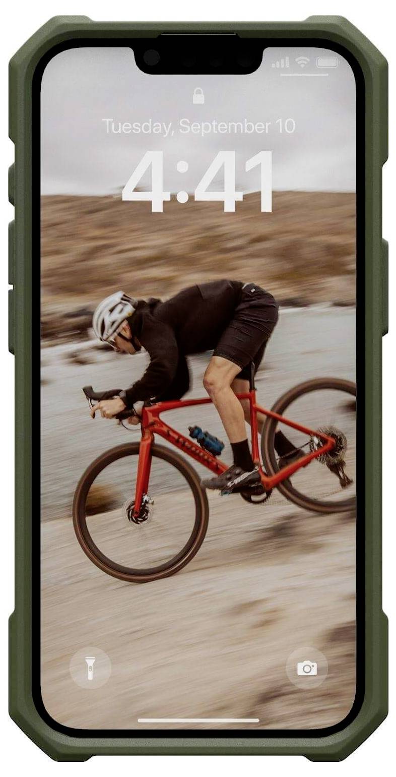 Ein Fahrradfahrer in sportlicher Kleidung fährt schnell auf einem roten Fahrrad über eine unscharfe, steinige Landschaft.