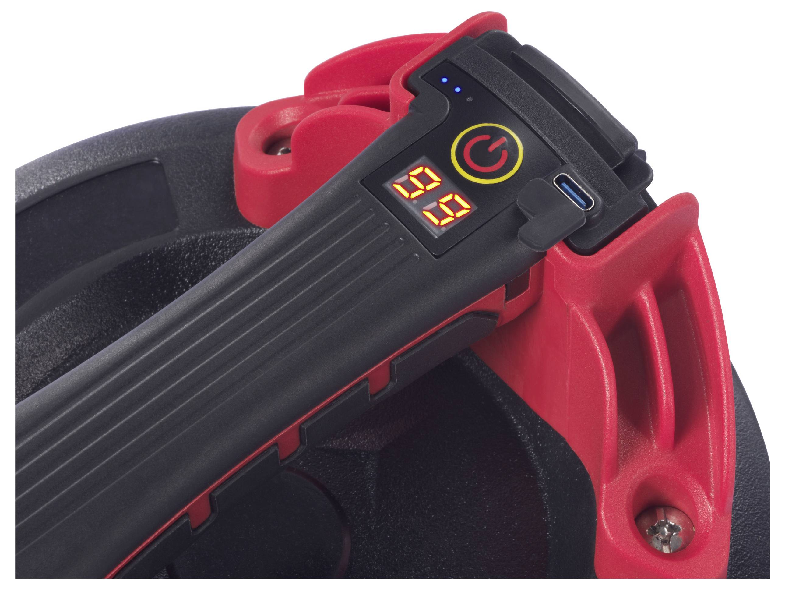 Nahaufnahme eines schwarzen und roten Geräts mit digitaler Anzeige und Ladeanschluss. Anzeige zeigt '99', Power-Knopf daneben leuchtet.