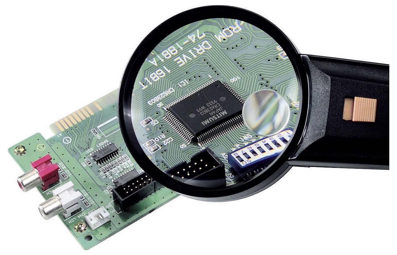 Lupe untersucht eine grüne Leiterplatte mit einem zentralen Chip und Anschlüssen, wobei elektronische Komponenten hervorgehoben werden.