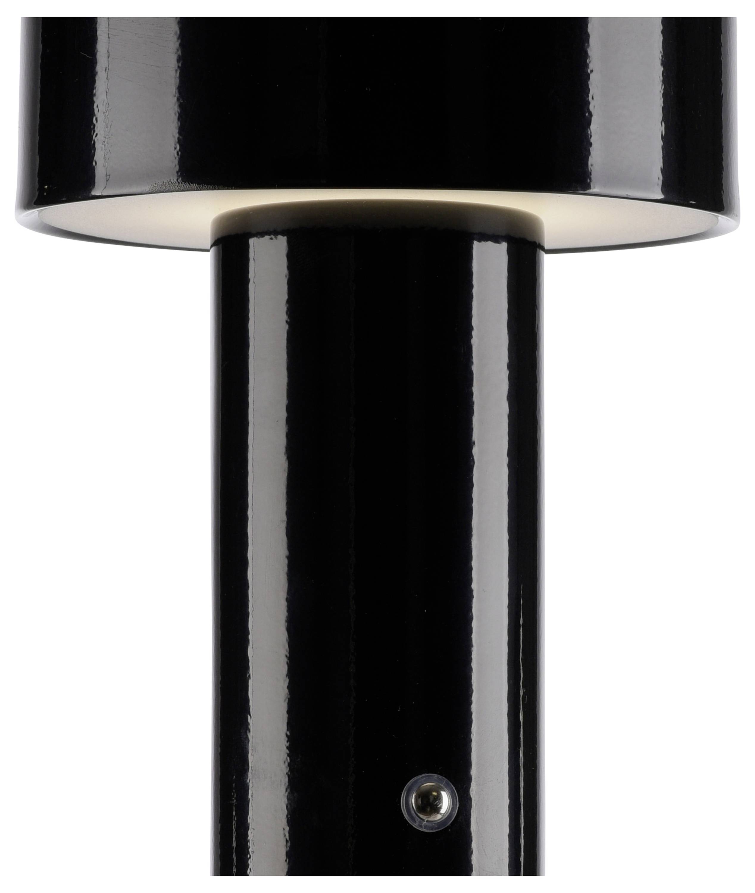Eine nah aufgenommene, schwarze, zylindrische Tischlampe, die von oben beleuchtet wird.