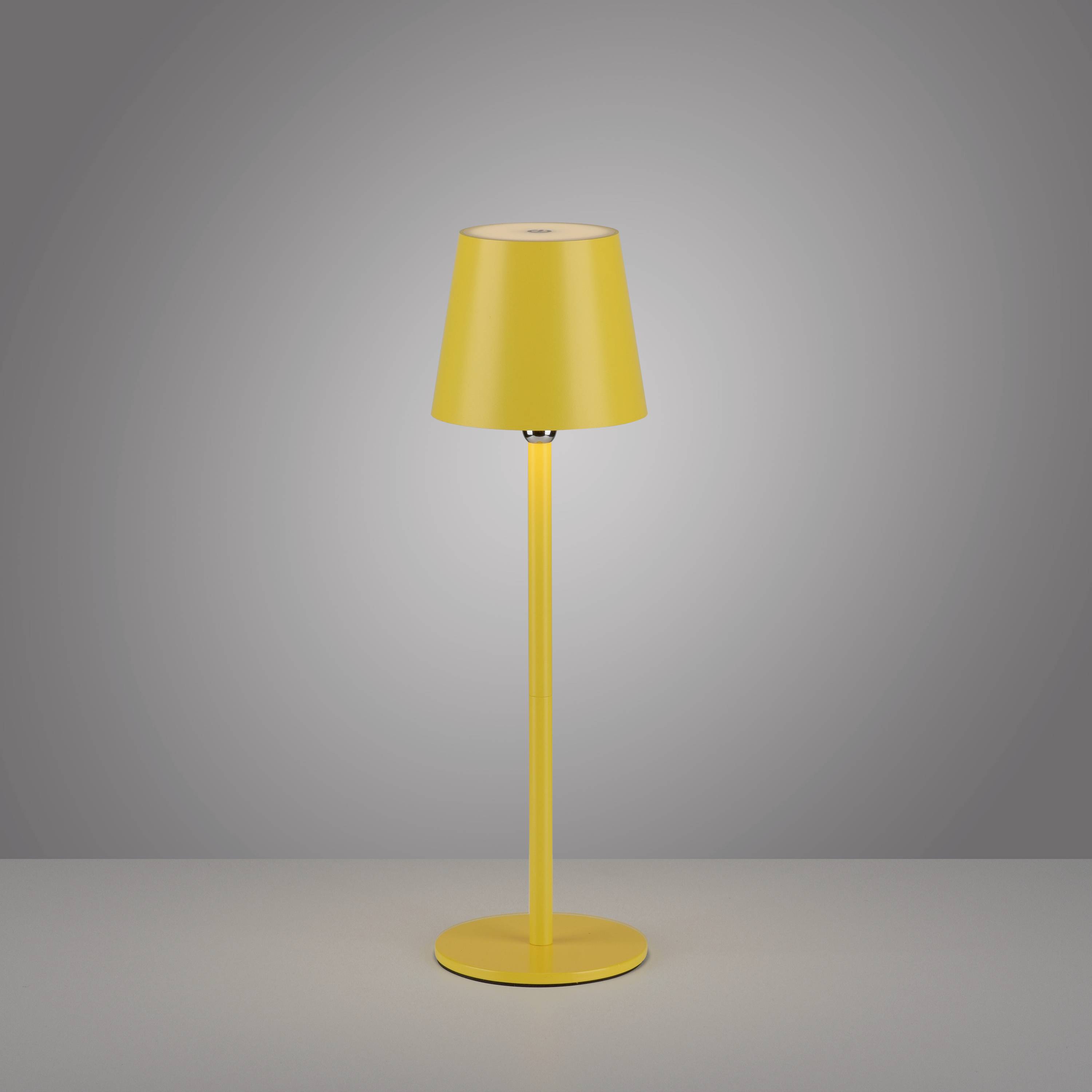 Gelbe Tischleuchte mit modernem Design vor grauem Hintergrund. Lampenfuß und Schirm in kräftigem Gelb.