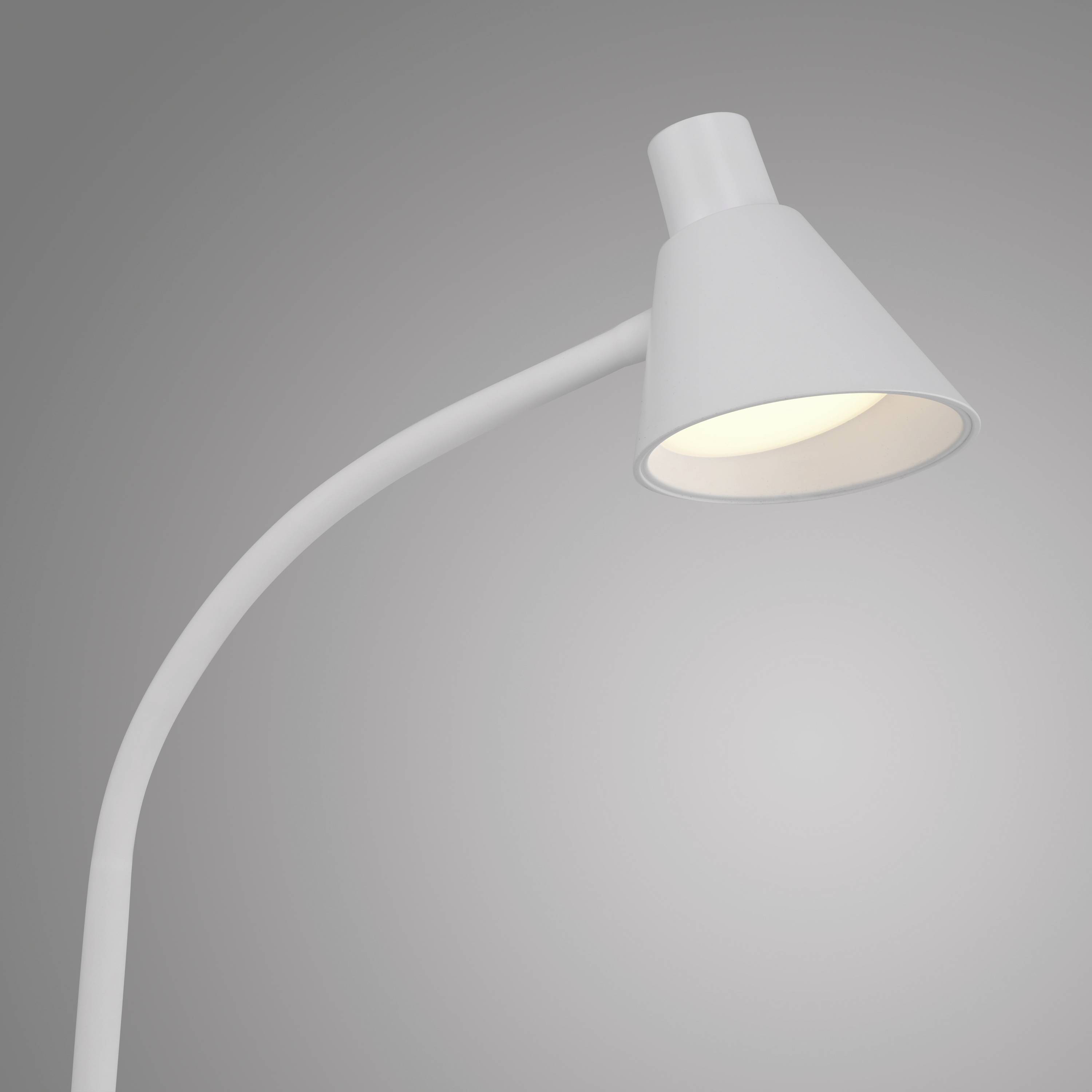 Eine moderne weiße Schreibtischlampe leuchtet in einem schlichten, minimalistischen Design.