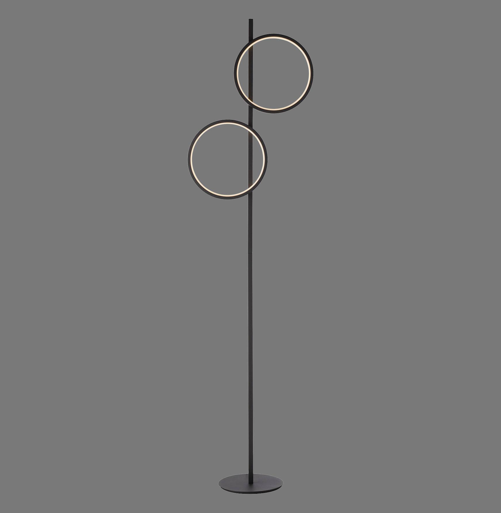 Stehlampe mit zwei leuchtenden Ringen, die übereinander an einem schlanken, dunklen Ständer befestigt sind, auf grauem Hintergrund.