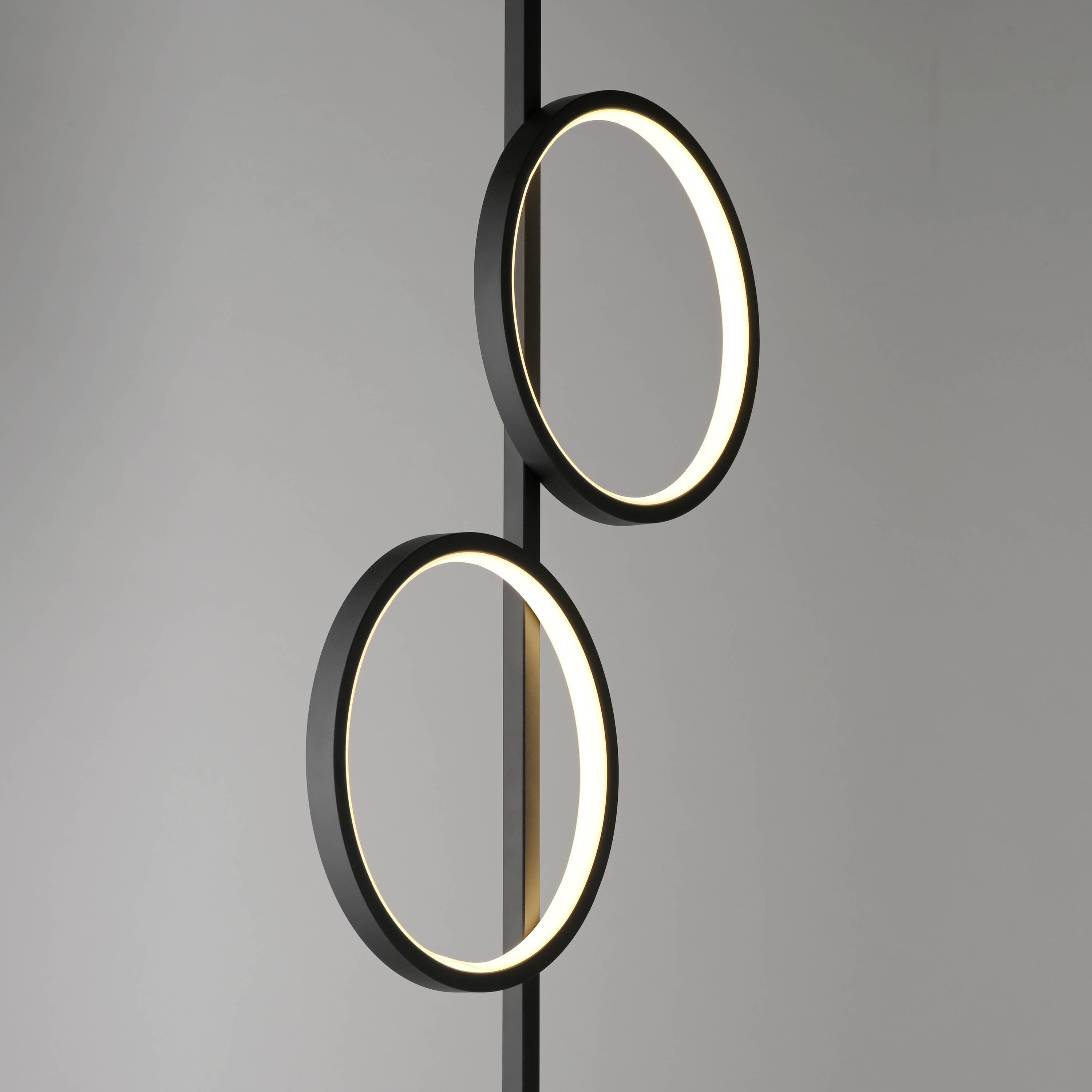 Zwei moderne, schwarze, kreisförmige Lampenringe mit warmem Leuchten, vertikal angeordnet vor grauem Hintergrund. Minimalistisches Design.