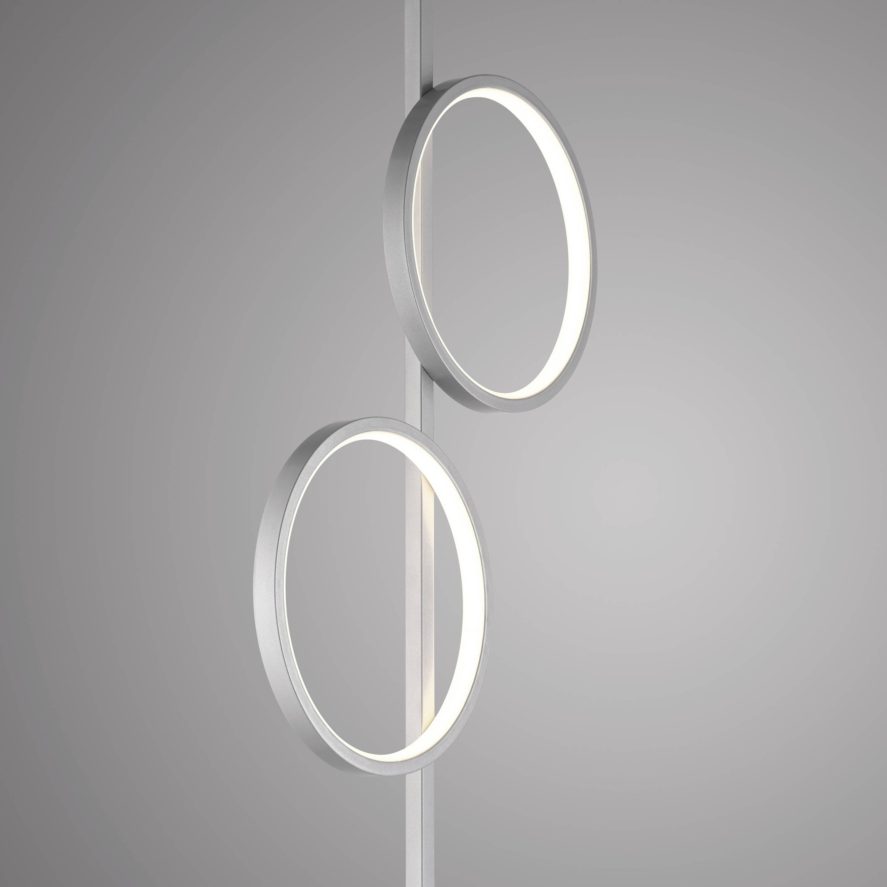 Zwei vertikale Leuchtringe an einer Stange vor grauem Hintergrund, moderner minimaler Stil, fungieren als dekorative Beleuchtung.