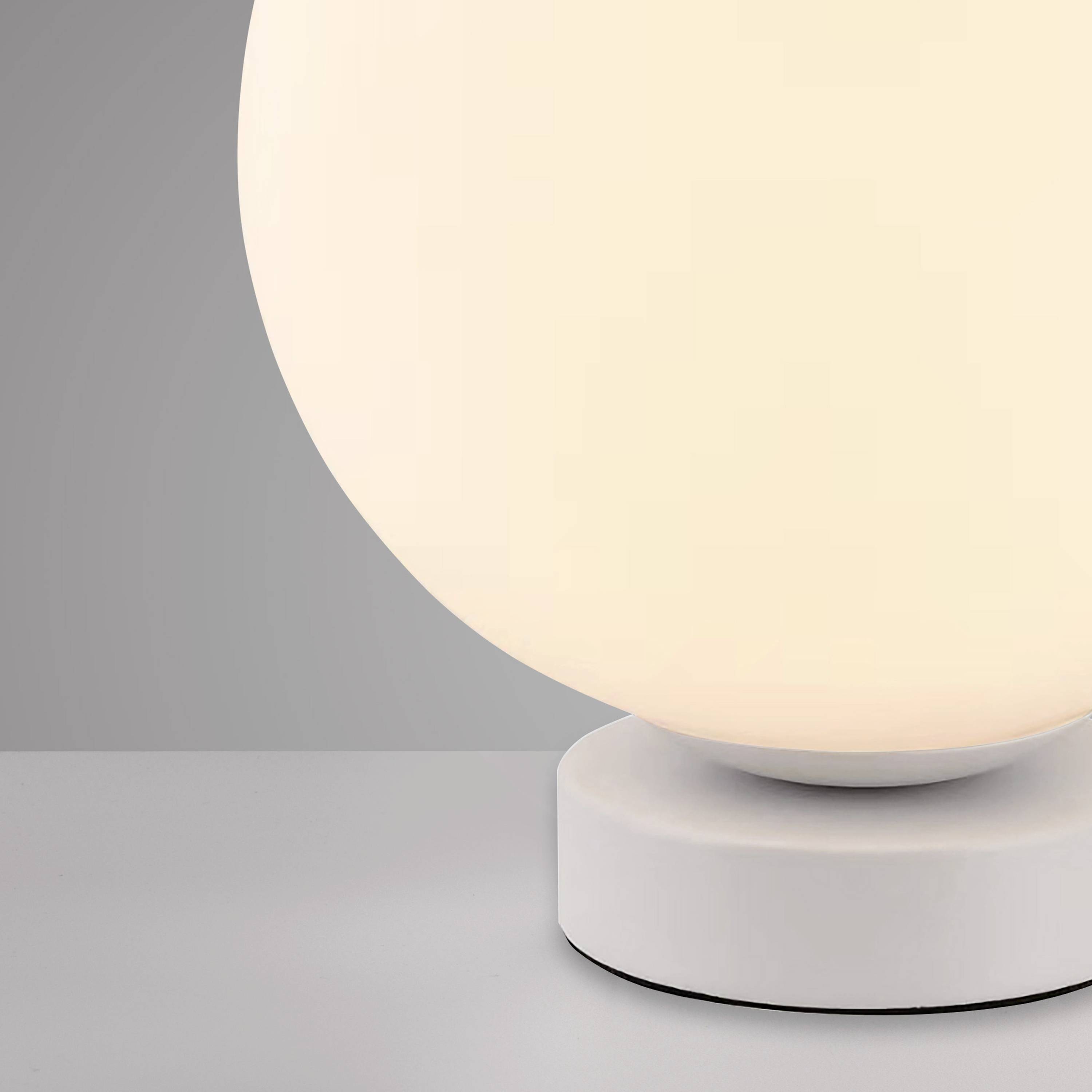 Eine runde, leuchtende Tischlampe mit weißem Schirm auf einem flachen, zylindrischen Sockel vor grauem Hintergrund.