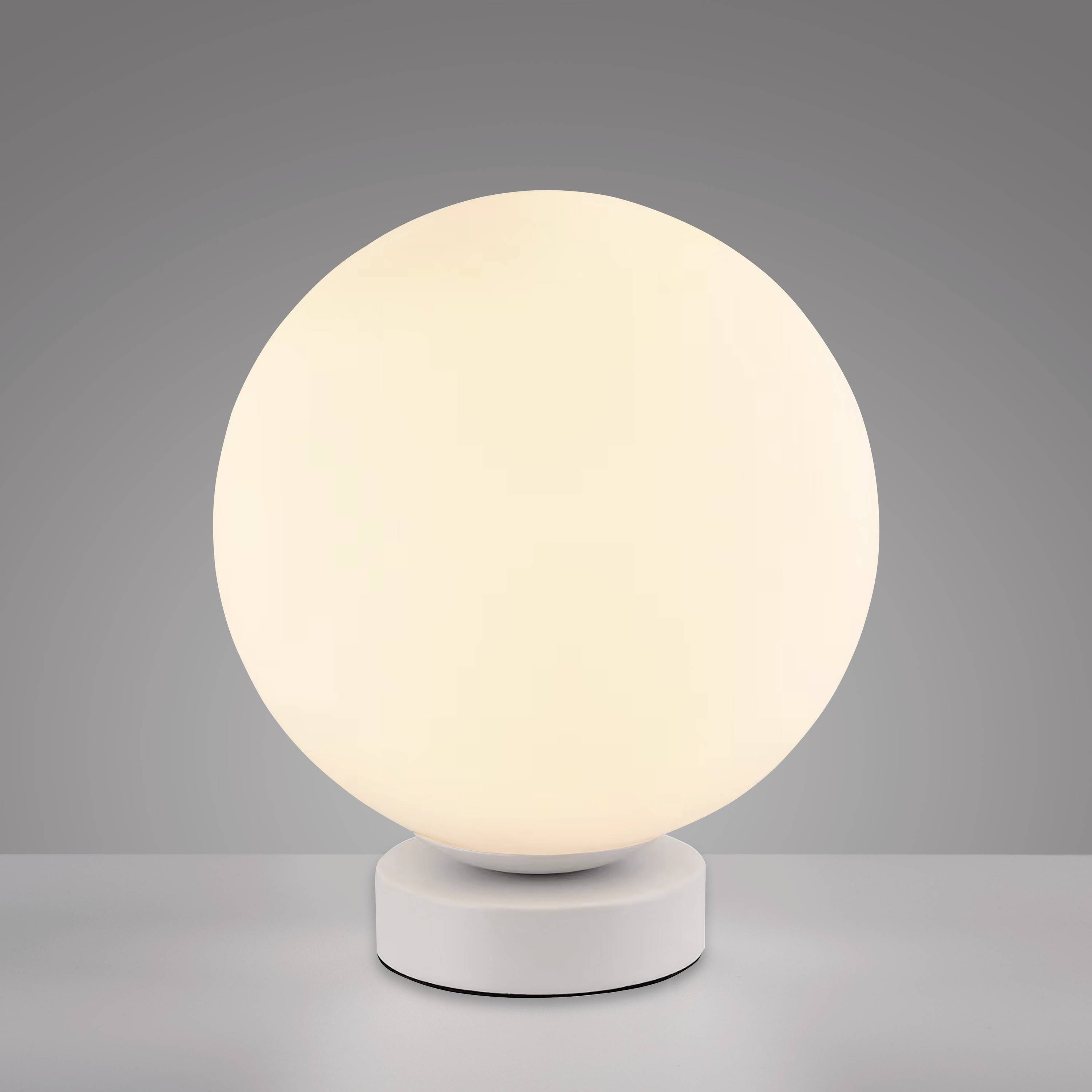 Runde Tischlampe mit weißem, leuchtenden Glas auf einem grau-weißen Sockel vor grauem Hintergrund.