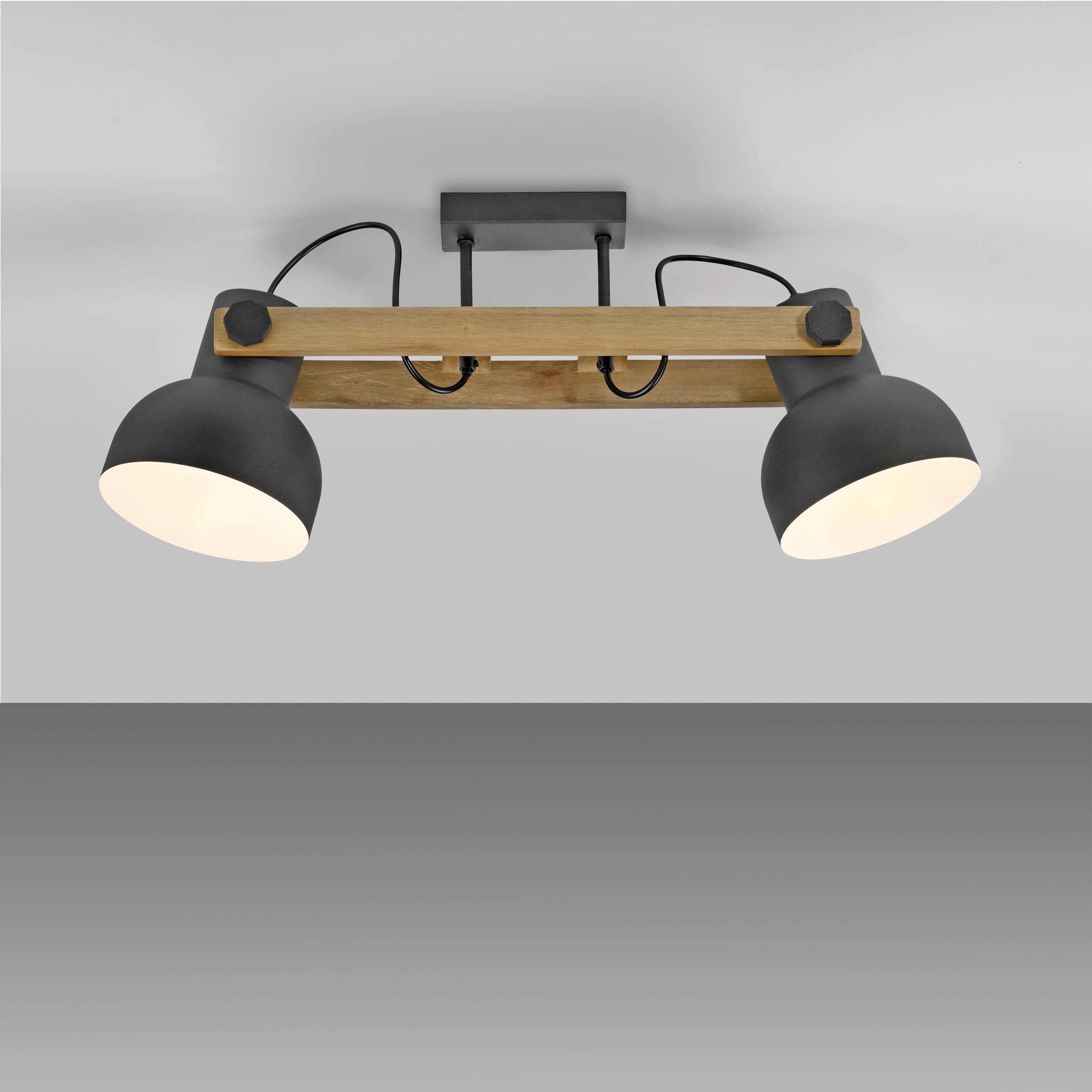 Zwei schwarze Deckenleuchten an einem Holzträger, montiert an einer grauen Decke. Geeignet für moderne Innenräume.
