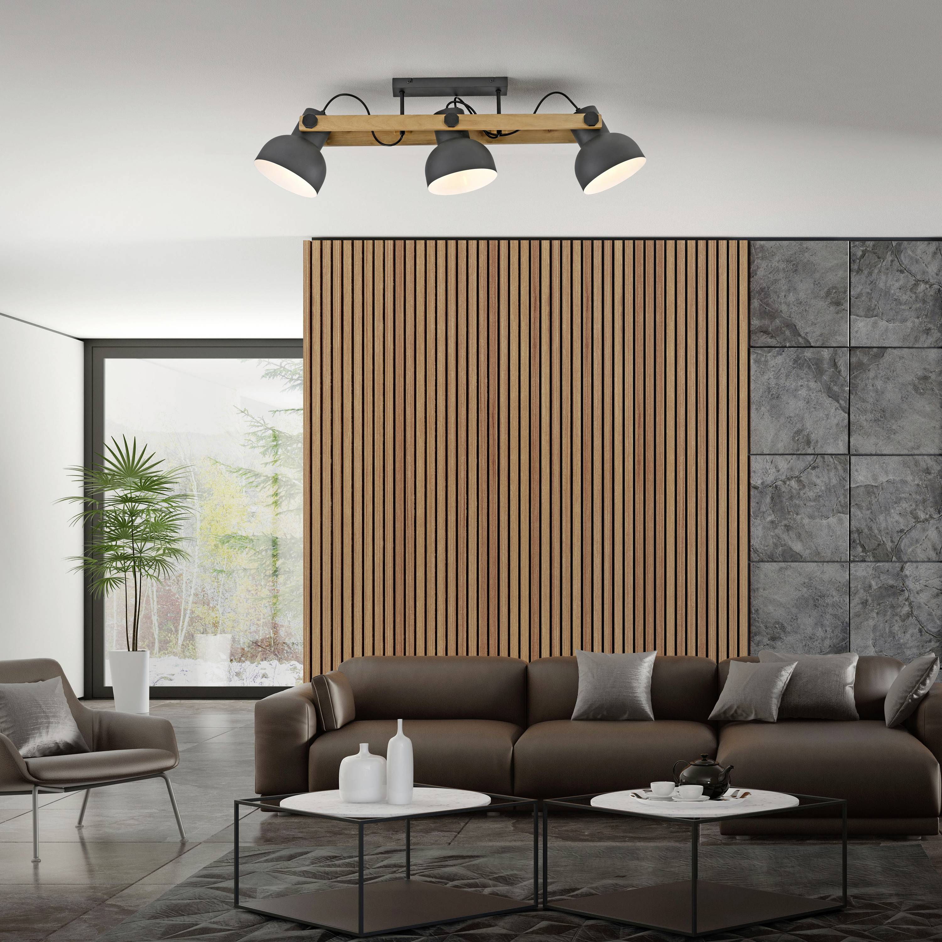 Wohnzimmer mit grauem Sofa, rundem Couchtisch, modernen Stehlampen und Holzvertäfelung an der Wand; große Fenster mit Blick auf Pflanzen.