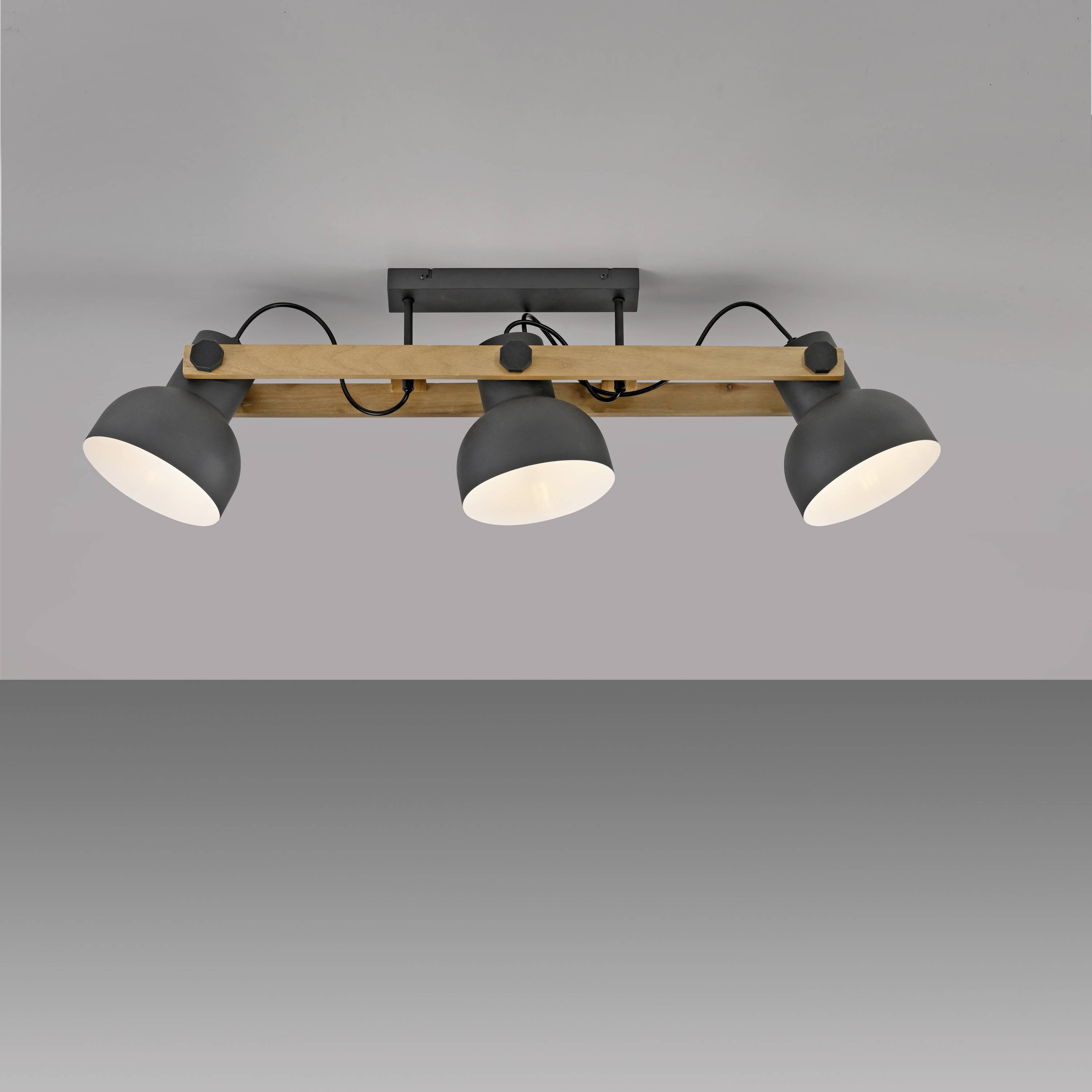 Schlichte Deckenleuchte mit drei verstellbaren, runden Spots auf einem Holz- und Metallrahmen, geeignet für moderne Innenräume.