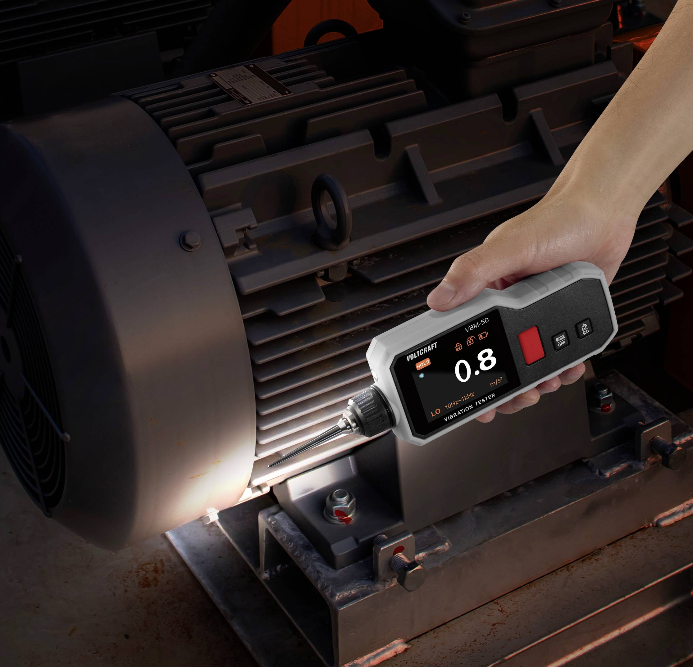 Eine Hand bedient einen digitalen Drehmomentschlüssel an einem industriellen Motor und zeigt auf dem Bildschirm eine Drehmomentanzeige von 0,8.