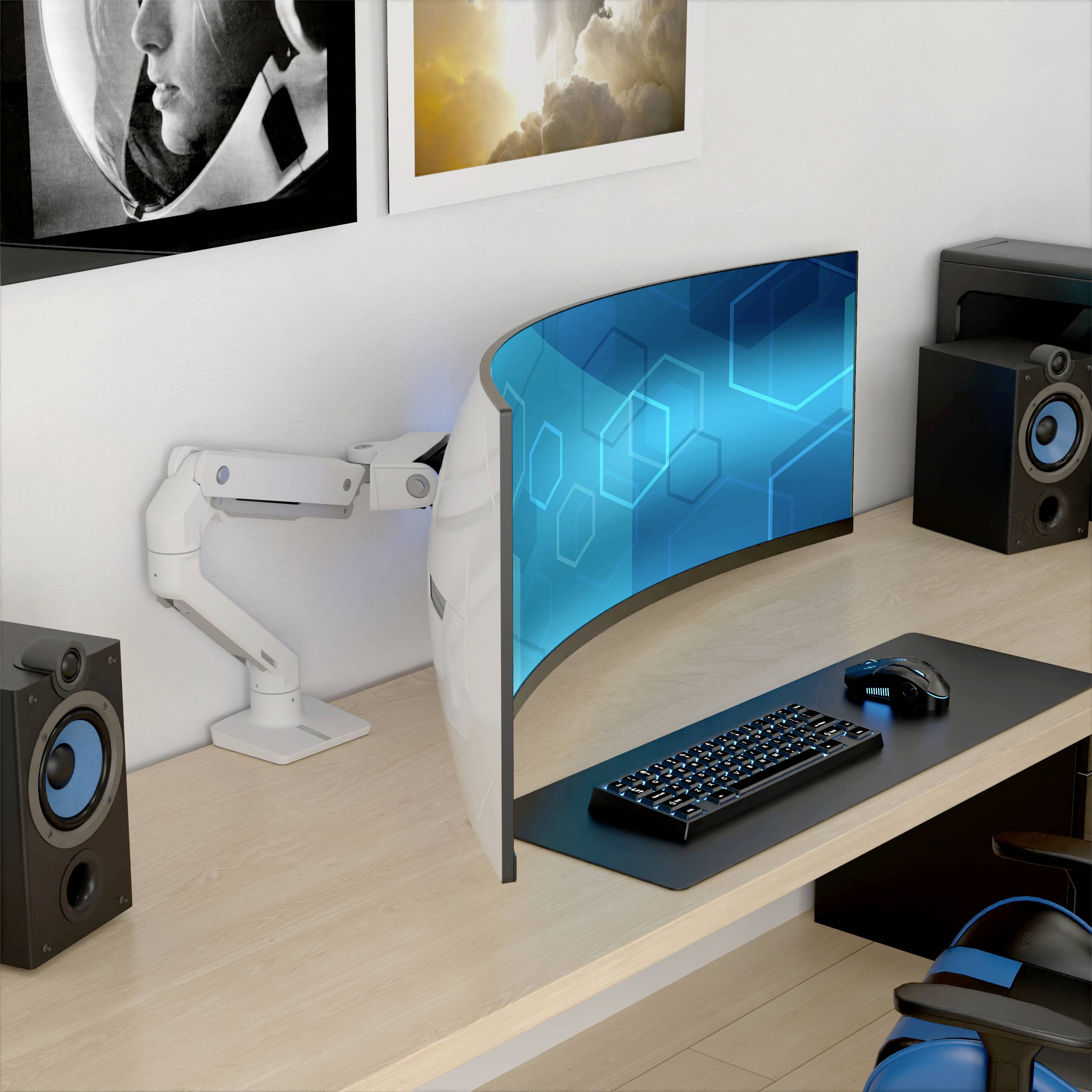 Ein moderner Schreibtisch mit geschwungenem Monitor, Tastatur, Maus und Lautsprechern auf hellem Holz. An der Wand sind Poster angebracht.