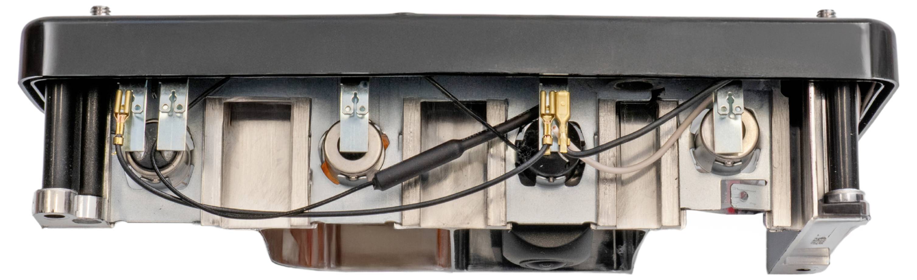 Untere Ansicht eines rechteckigen mechanischen Geräts mit mehreren runden Komponenten und Verdrahtung, wahrscheinlich Teil einer Industriemaschine.