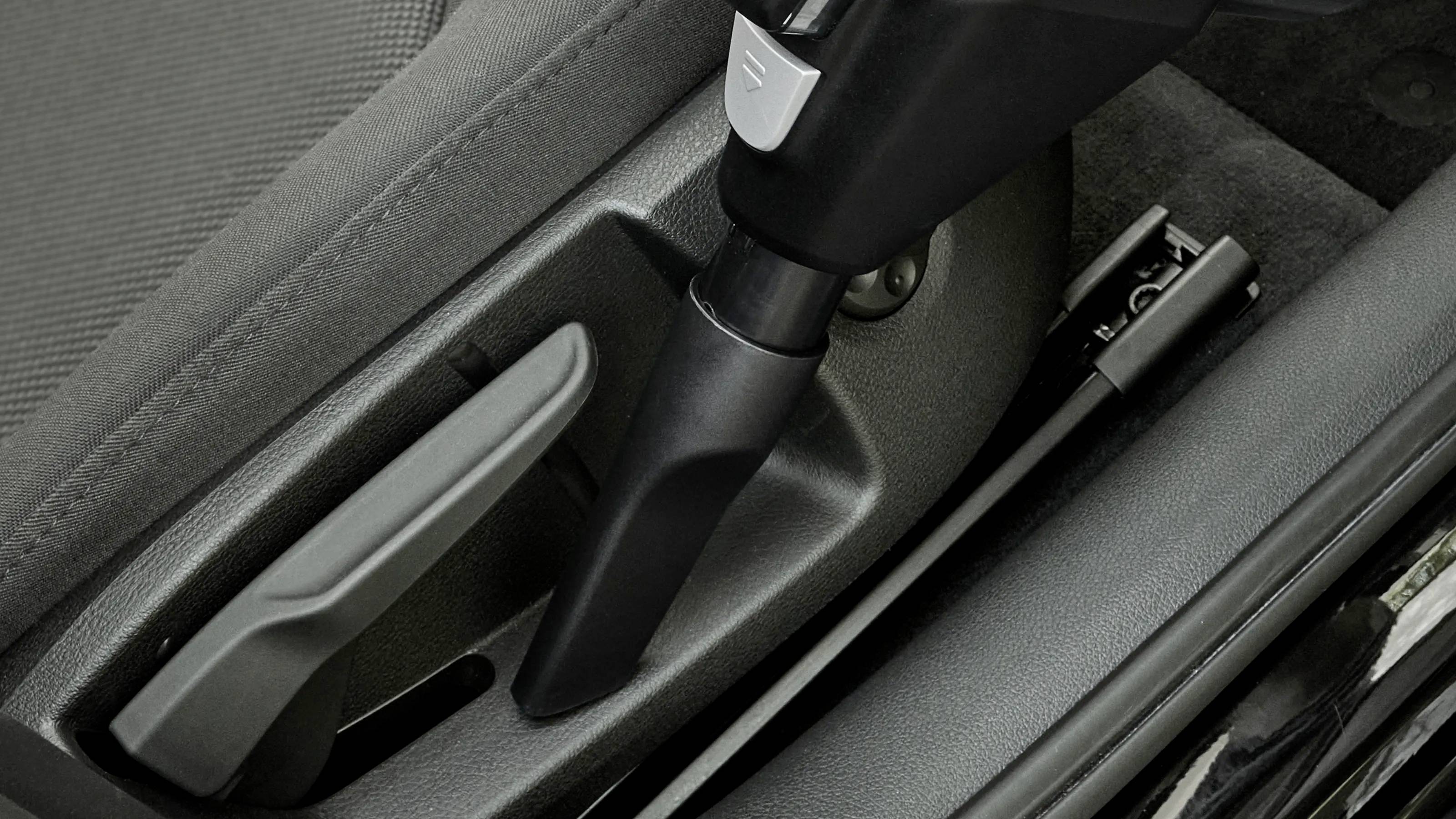 Handbremse eines Autos in der Mittelkonsole. Sie ist in der Nähe des Fahrersitzes positioniert und leicht zugänglich.