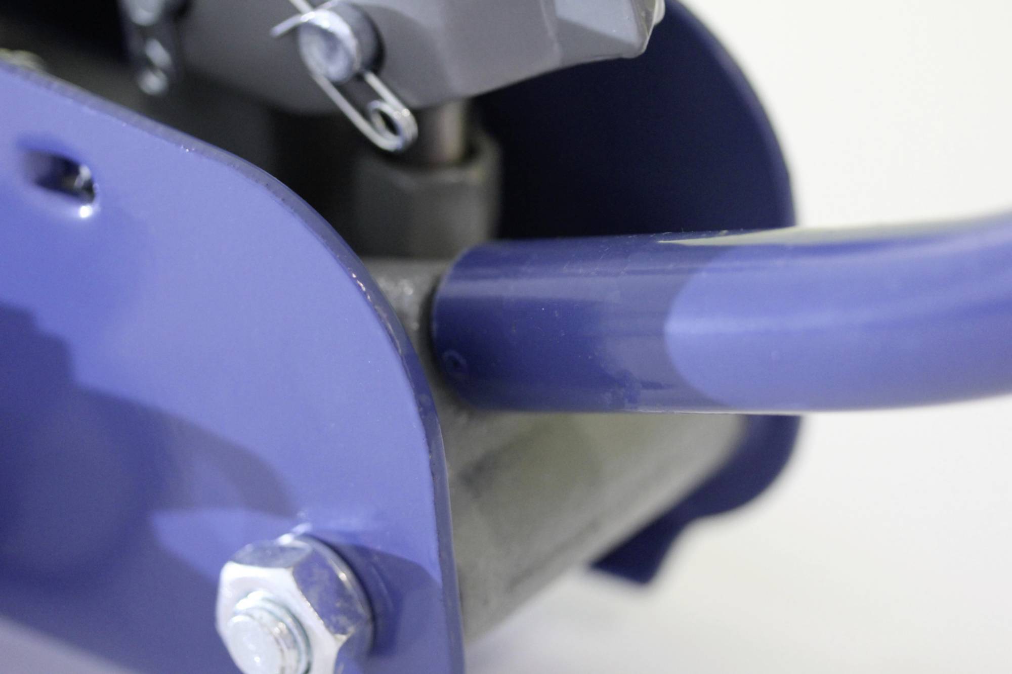 Maschinenteil in Nahaufnahme mit blauer Metallkomponente und Schraube, industrieller Kontext.