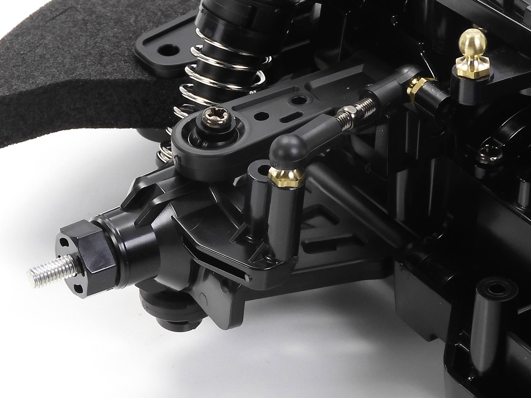 Nahaufnahme eines RC-Auto-Federungssystems mit Federn, Stoßdämpfern und Kugelgelenken, die Details der Mechanik zeigen.