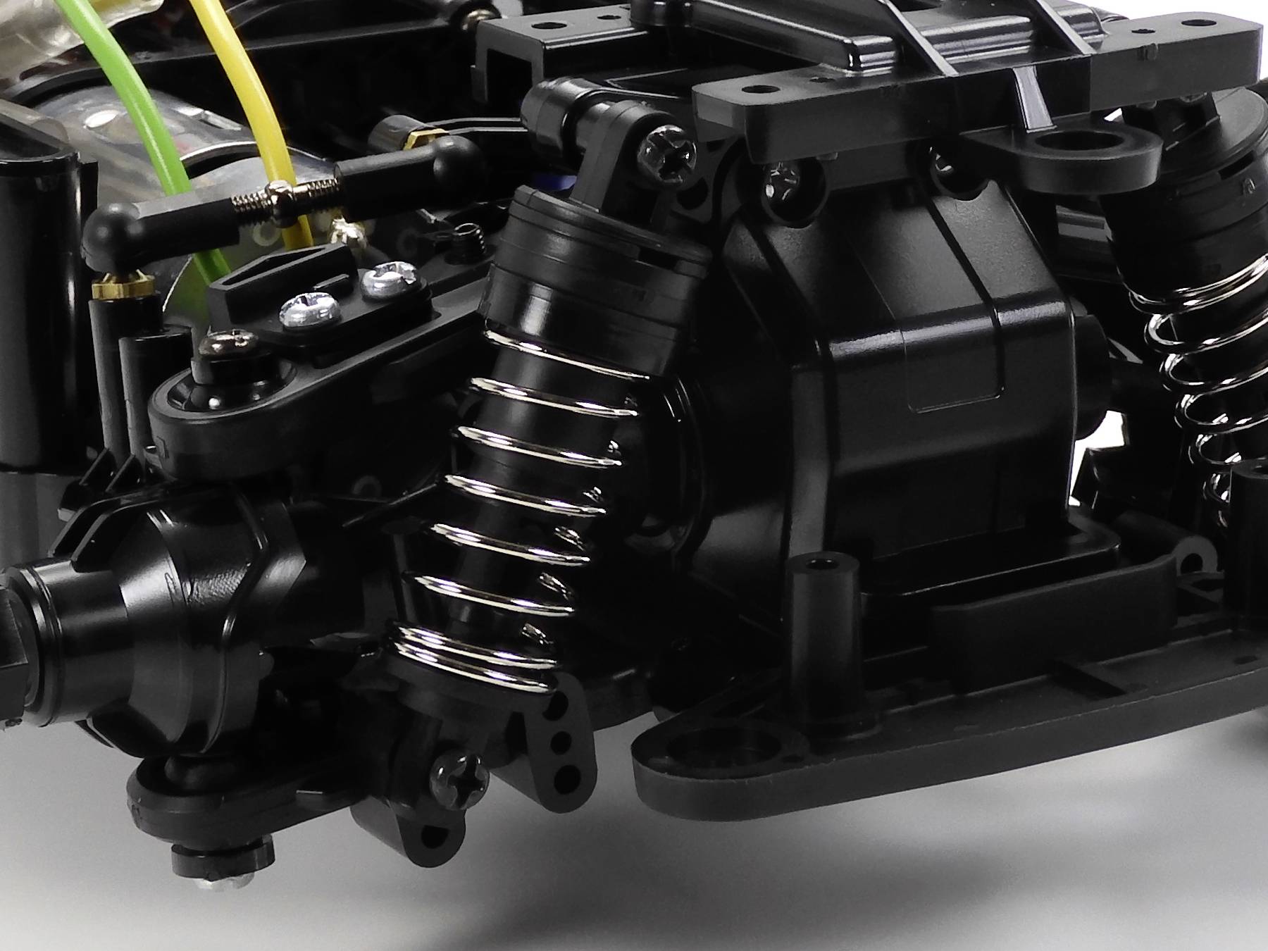 Nahaufnahme eines schwarzen Maschinenteils mit Federn und Kabeln, zeigt technische Details und Bauweise.