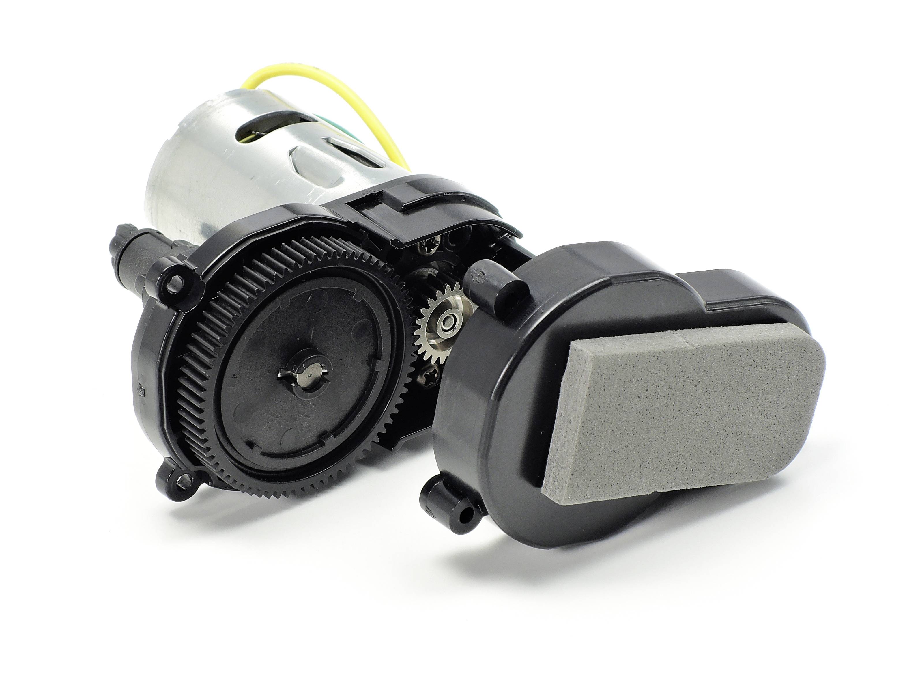 Ein kleiner Elektromotor mit Zahnradgetriebe und Kunststoffgehäuse, angeschlossener Kabel zur Stromversorgung.