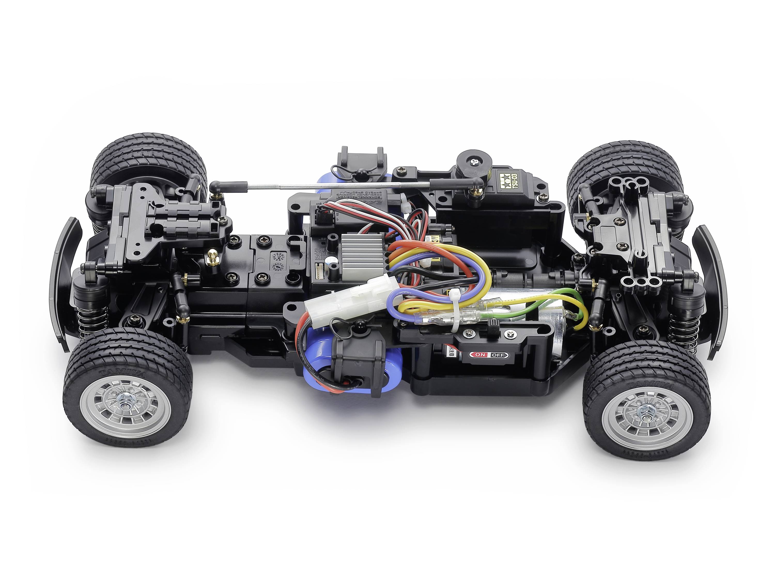 Fernsteuerbares Auto-Chassis mit sichtbaren Motoren und Kabeln, ohne Karosserie. Vier Räder sind montiert, technische Details erkennbar.