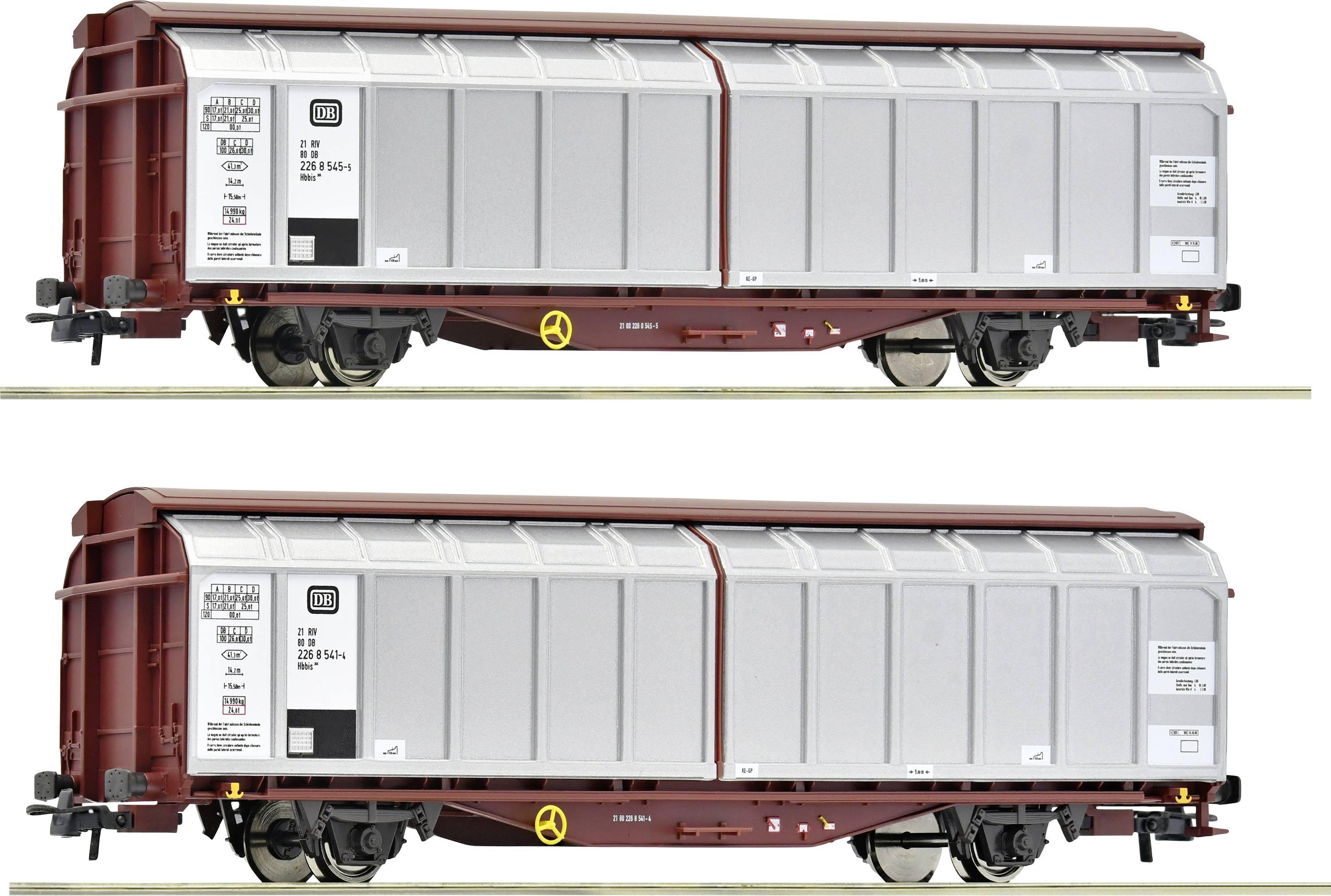 Zwei Güterwaggons auf Gleisen, grau mit roten Details. Sichtbar sind Beschriftungen und gelbe Handräder an den Seiten.