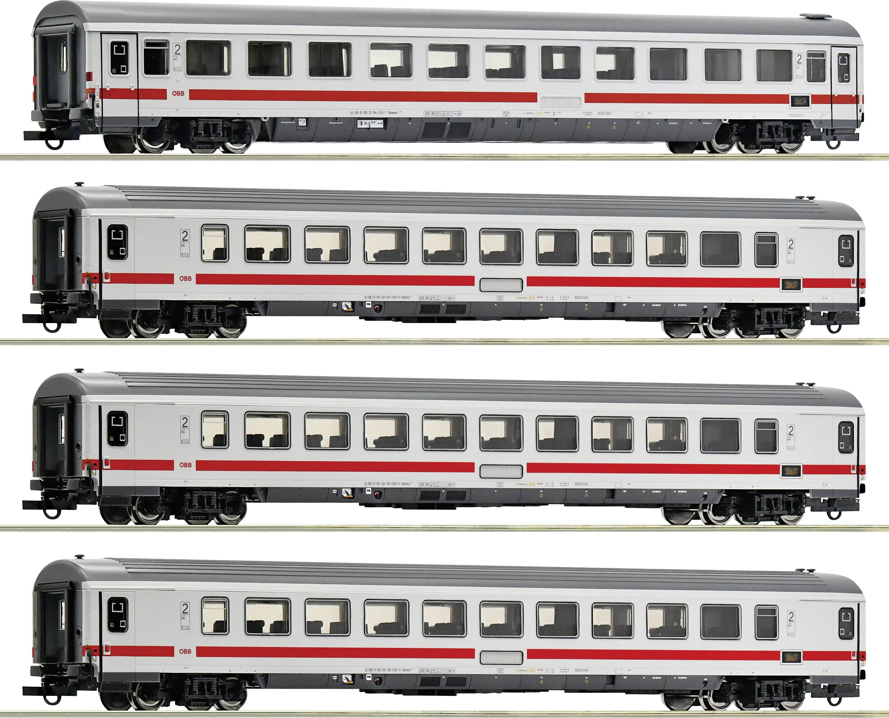 Vier silberne, moderne Personenzugwaggons in einer Reihe, mit roten Streifen an den Seiten. Alle Waggons haben gleichmäßige Fenster.