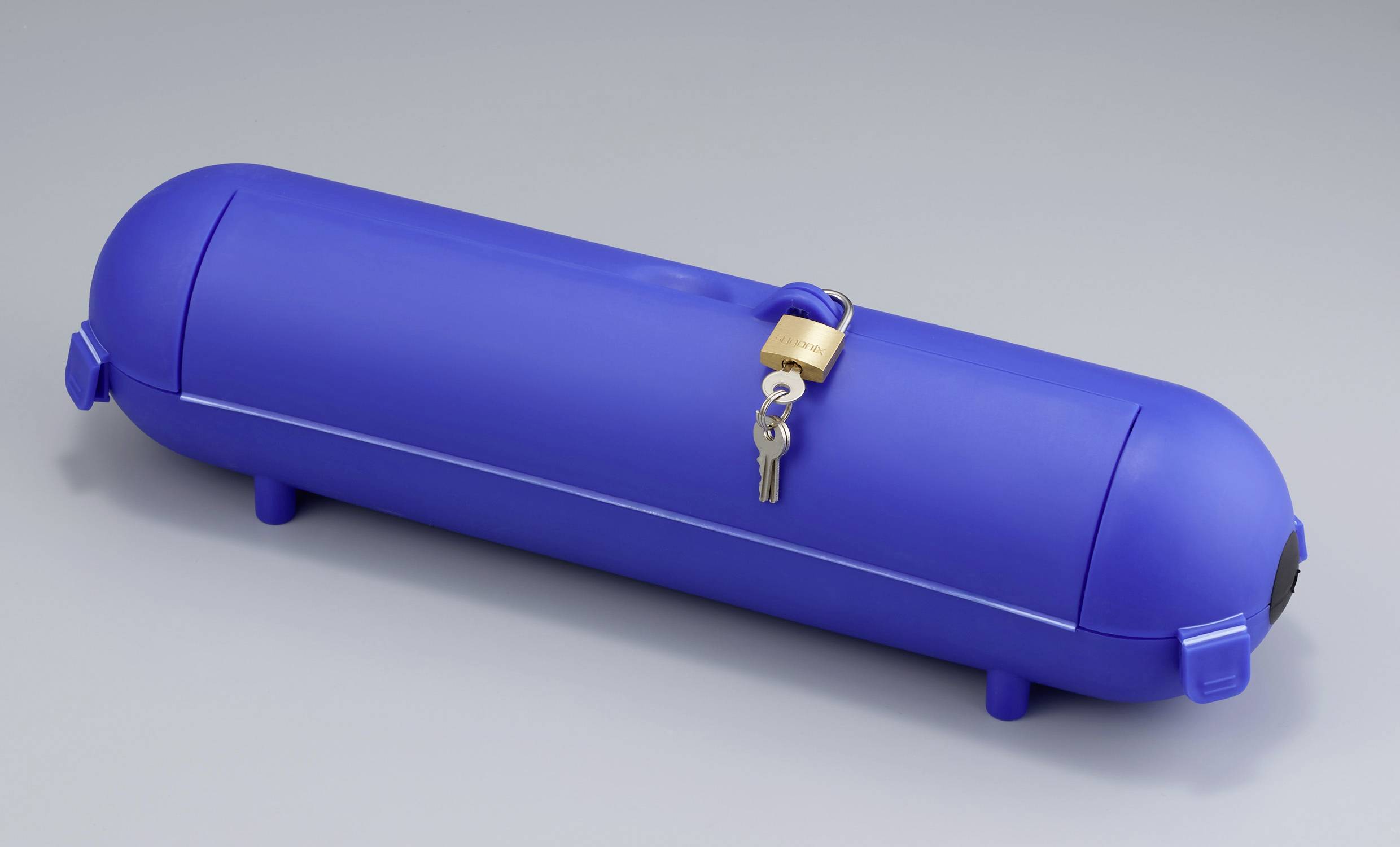 Ein langer blauer Behälter mit einem Vorhängeschloss und Schlüssel darauf. Der Behälter steht auf kleinen stabilen Füßen.