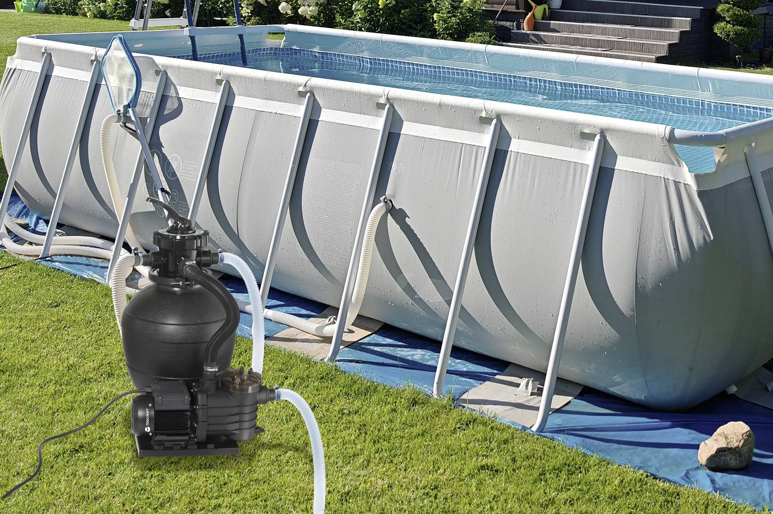 Ein großer, rechteckiger Aufstellpool im Garten, mit angeschlossener Sandfilterpumpe zur Reinigung des Wassers.