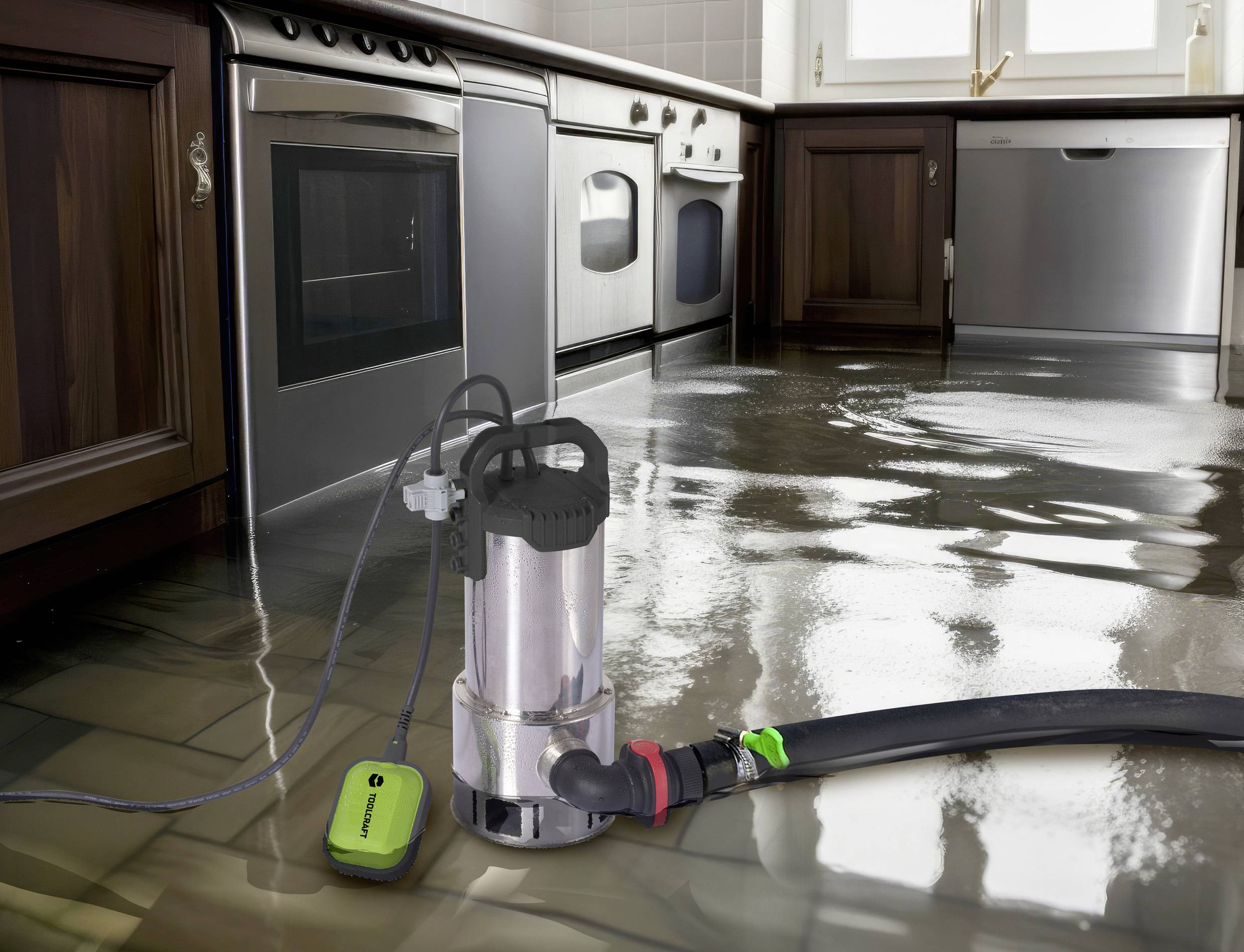 Eine Tauchpumpe entfernt Wasser von einem Küchenboden, um eine Überschwemmung zu bekämpfen. Im Hintergrund sind Küchengeräte sichtbar.