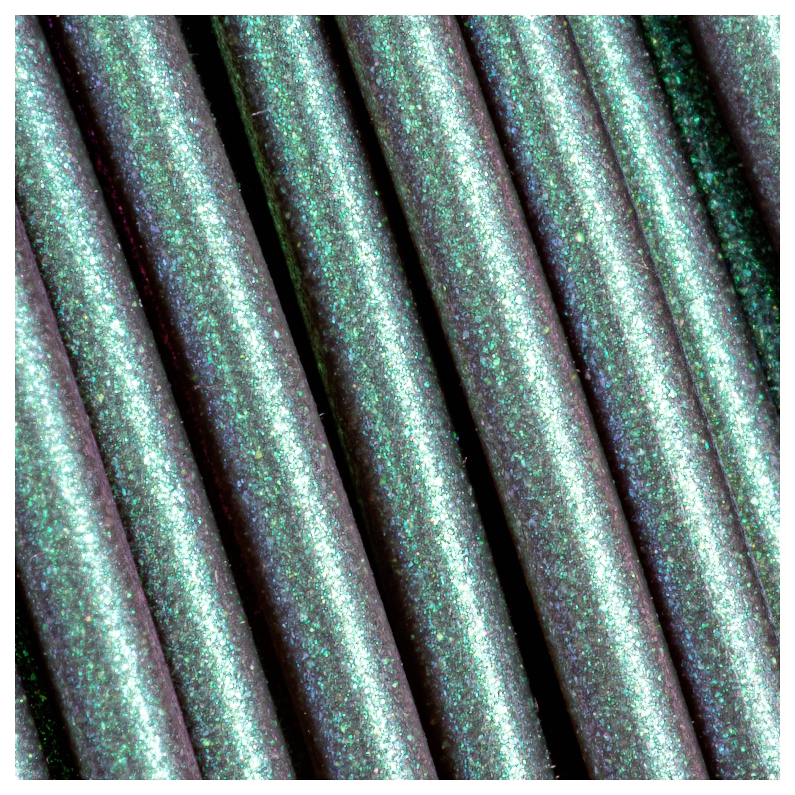 Mehrere grün glitzernde Stifte nebeneinander in Nahaufnahme. Glitzerpartikel reflektieren das Licht, was einen leuchtenden Effekt erzeugt.