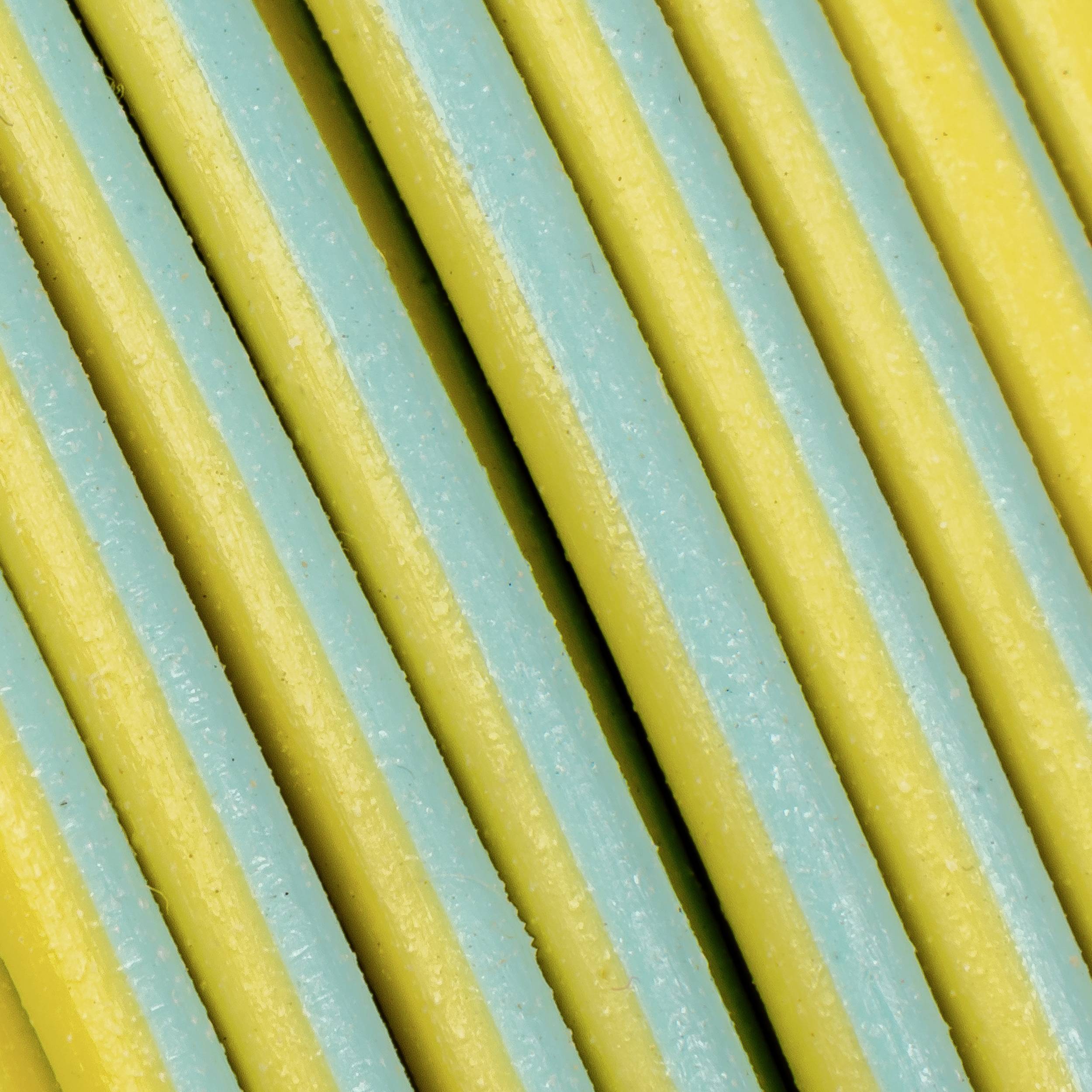 Nahaufnahme von gelben und blauen Nudeln, parallel angeordnet, bietet ein interessantes Farbmuster und Textur.