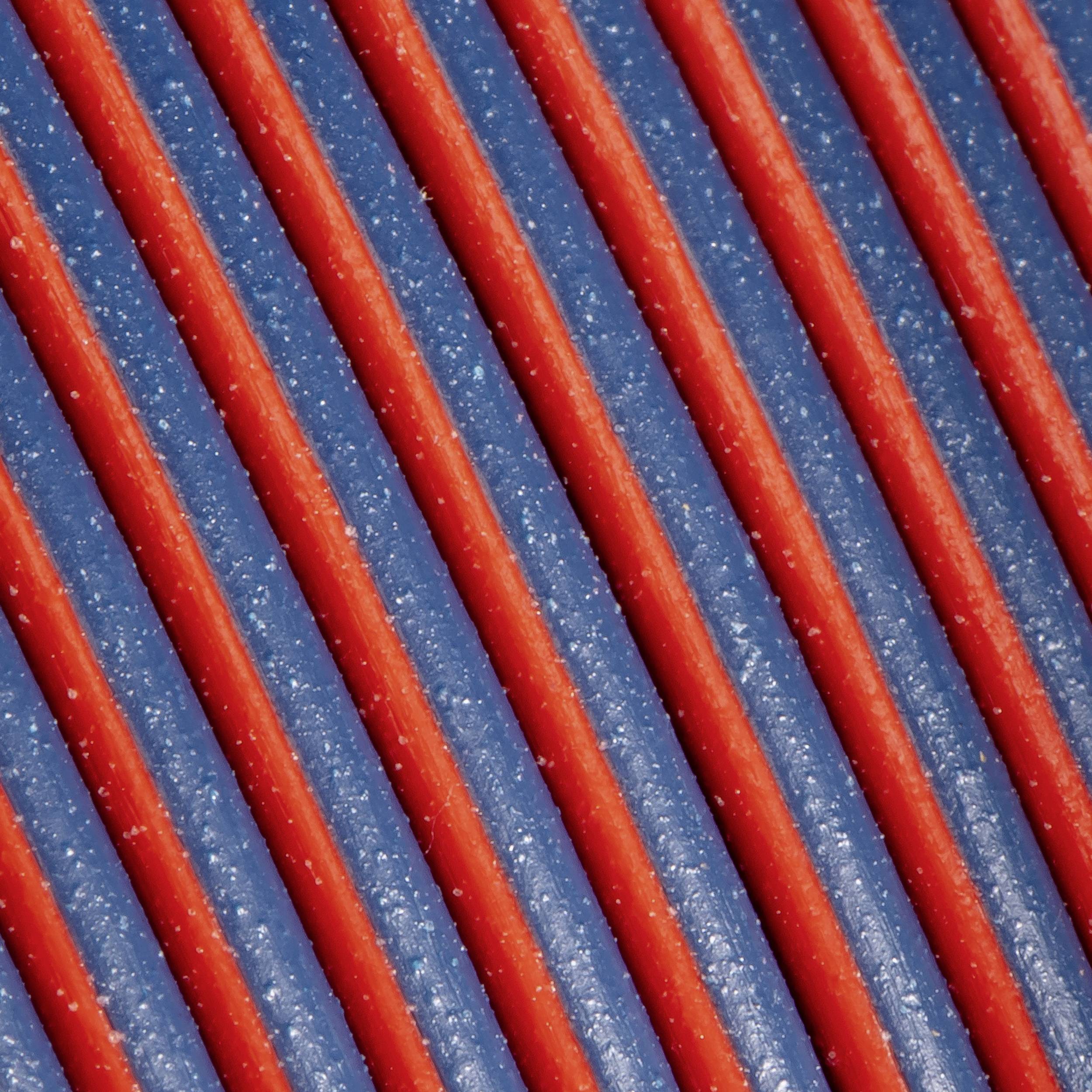 Nahaufnahme von rot und blau gestreiften Bahnen, die diagonal verlaufen. Die Textur wirkt körnig und reflektiert Licht.