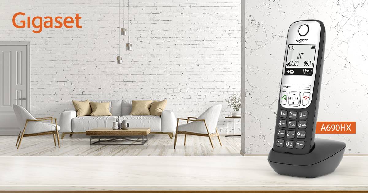 Schnurloses Gigaset A690HX Telefon in modernem Wohnzimmer, vor weißer Backsteinwand und beigem Sofa aufgestellt.