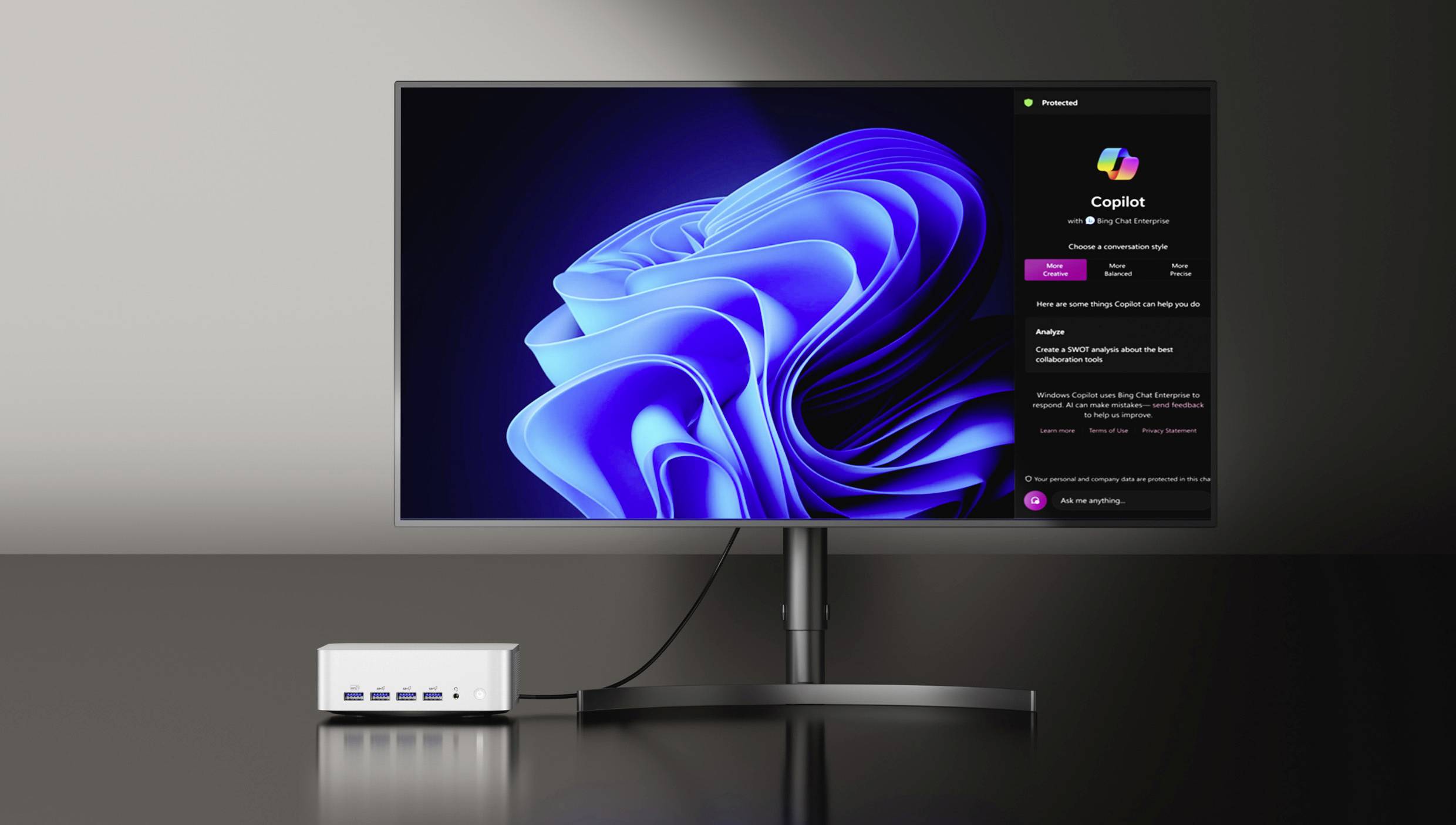 Ein Monitor zeigt ein abstraktes blaues Muster auf schwarzem Hintergrund. Daneben Informationen über 'Copilot', mit einem kleinen weißen Gerät unten links.