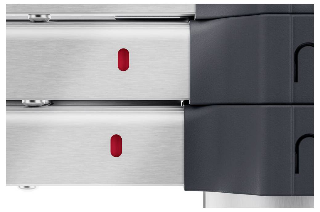 Zwei metallische Gleitschienen mit roten Markierungen, montiert neben eine schwarze Plastikstruktur.