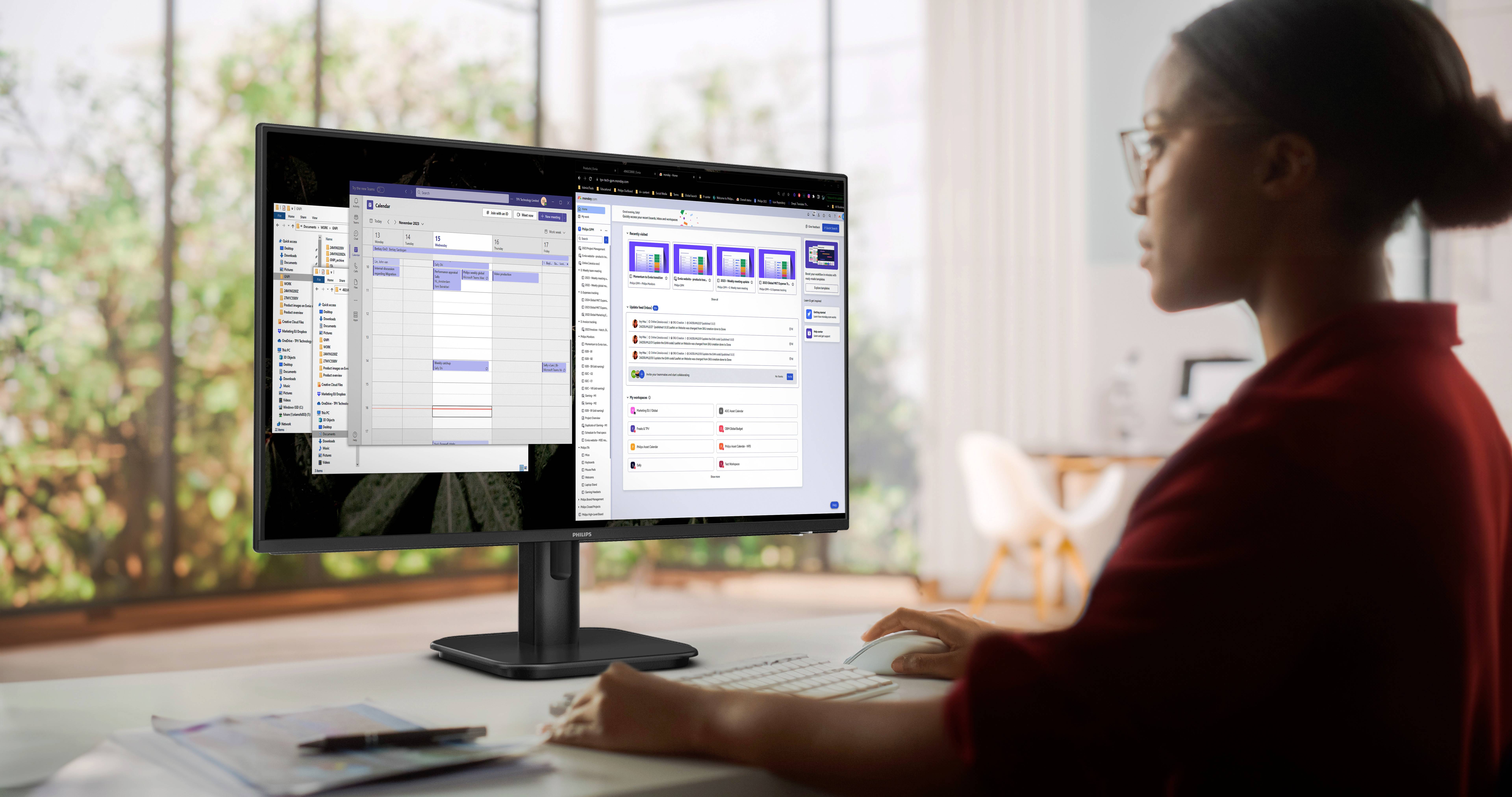 Eine Person arbeitet an einem Schreibtisch und blickt auf einen Computerbildschirm, der ein geöffnetes Kalender- und Kommunikationsprogramm zeigt.