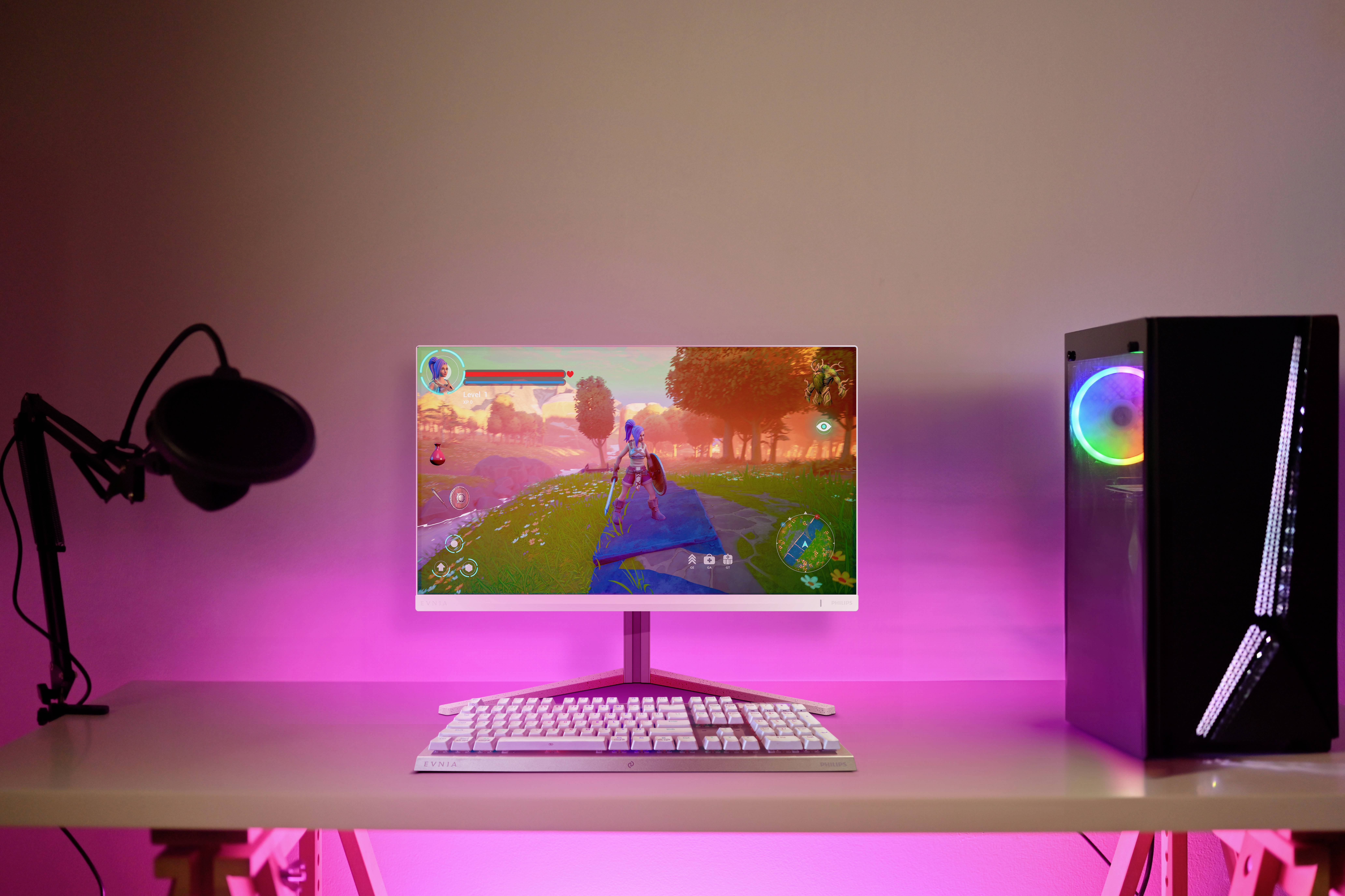 Ein Schreibtisch mit einem Computer, der ein Videospiel zeigt. Daneben steht ein schwarzes Mikrofon und ein Computergehäuse mit LED-Beleuchtung.