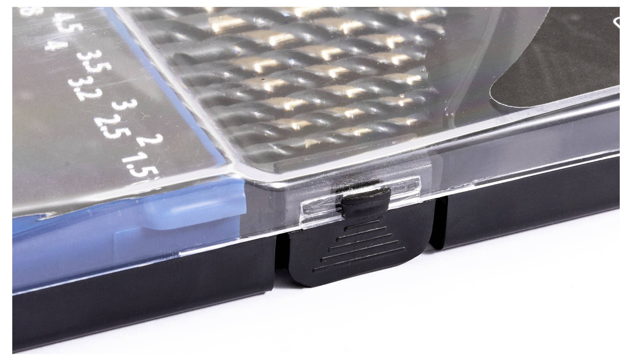 Nahaufnahme eines transparenten Kunststoff-Verschlusses auf einer Kiste, die detaillierte Textur und Zahlen an der Seite zeigt, möglicherweise für sichere Aufbewahrung oder Präsentation.