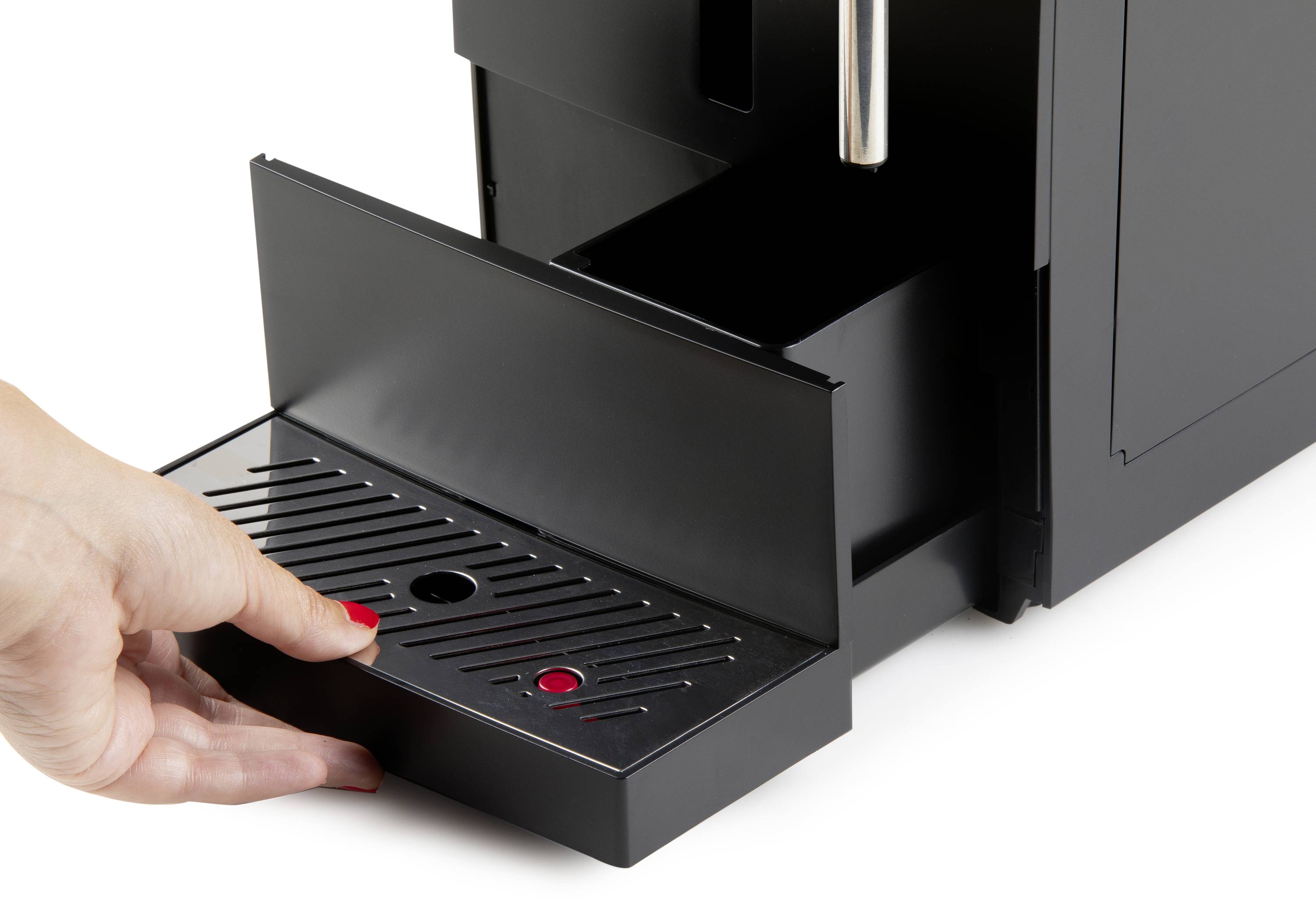 Eine Person zieht die Abtropfschale einer schwarzen Kaffeemaschine heraus, um sie zu entleeren oder zu reinigen.