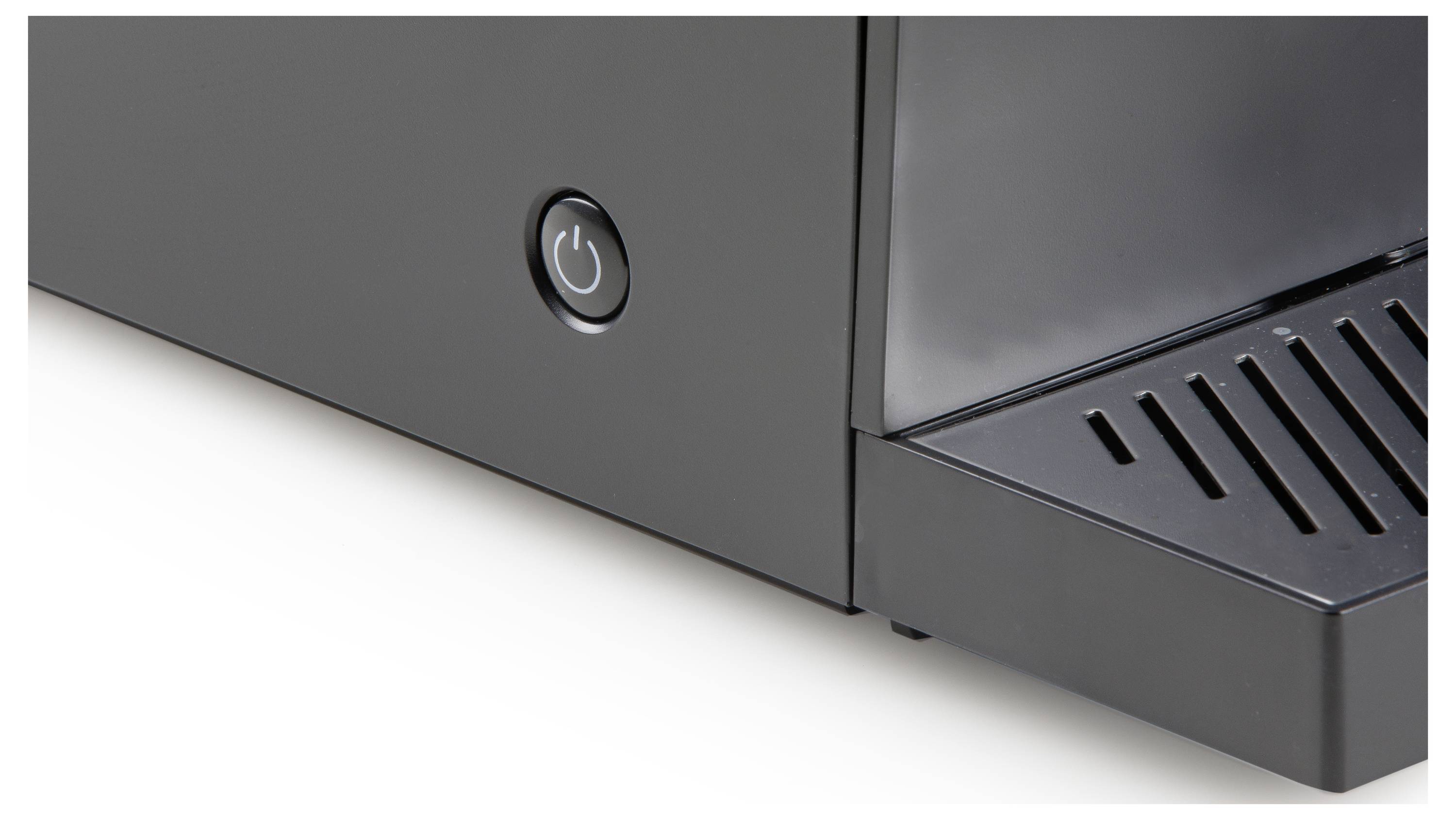 Ein Teil einer Kaffeemaschine ist sichtbar, mit einem inaktiven Ein-/Ausschalter und einem Abtropfgitter auf der rechten Seite.