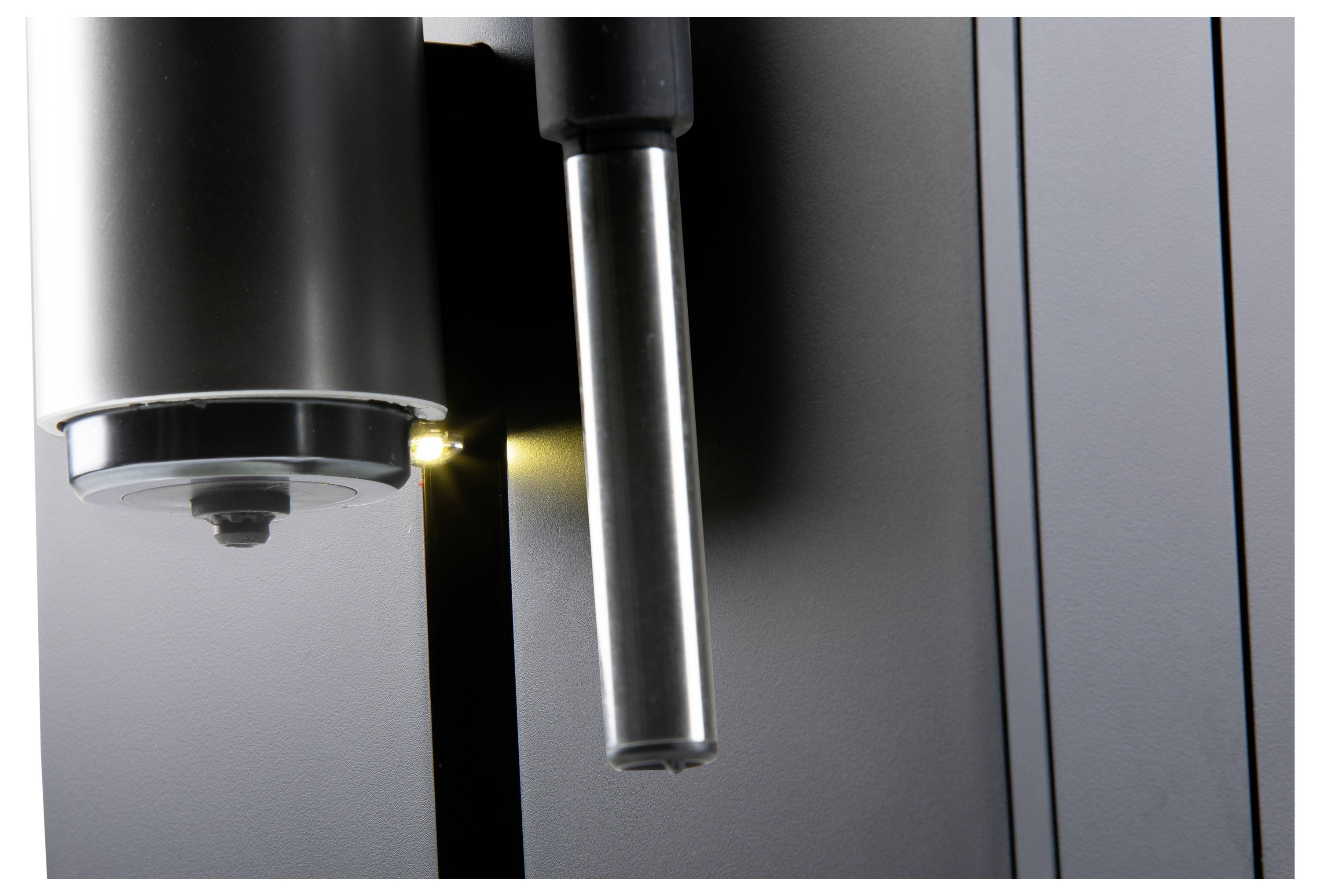 Ein Detailbild einer Metallmaschine mit einem zylindrischen Bauteil, das Licht reflektiert. Konzentration auf Material und Textur.