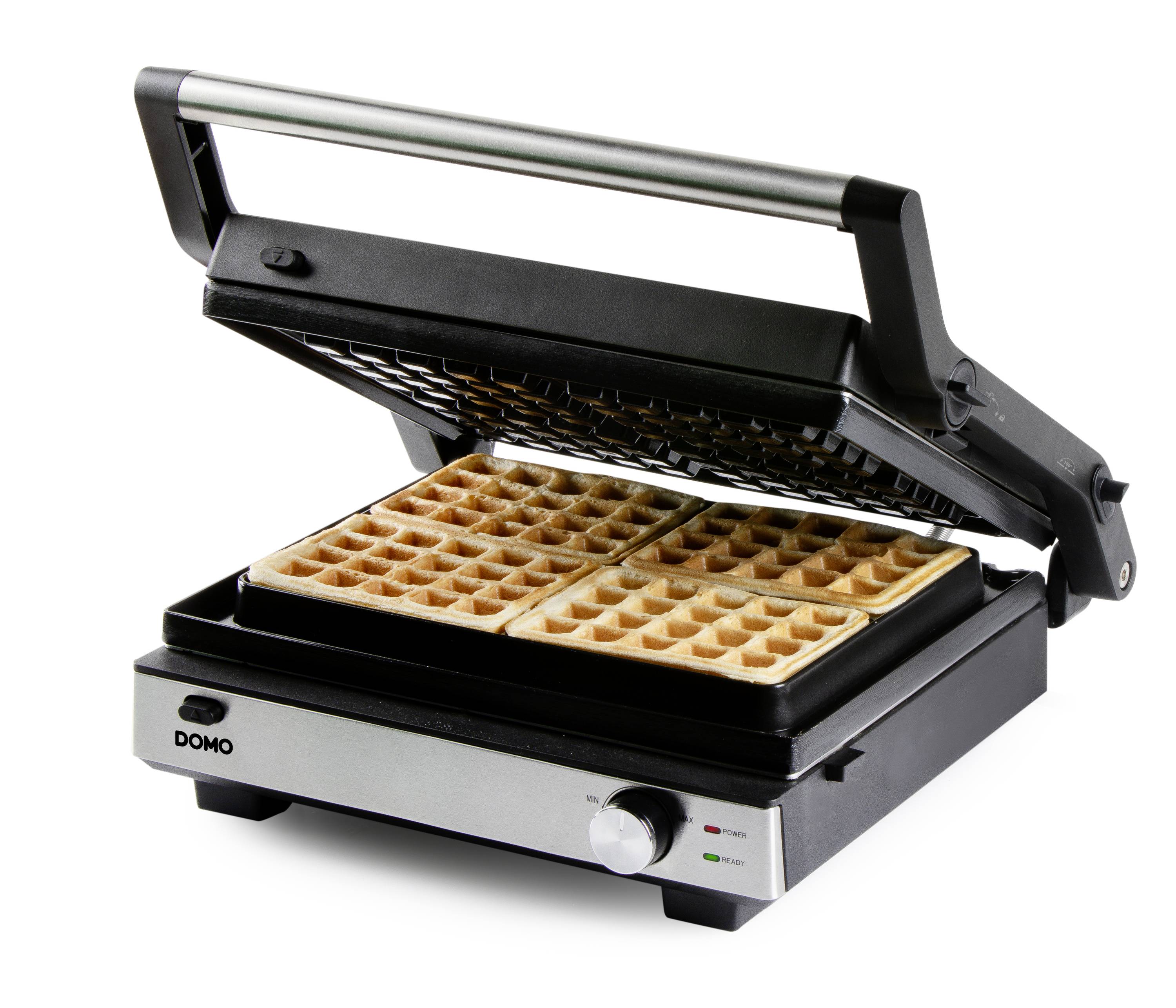 Ein elektrisches Waffeleisen mit geöffneter Klappe zeigt fertige rechteckige Waffeln. Die Anzeigeleuchten sind grün und rot.