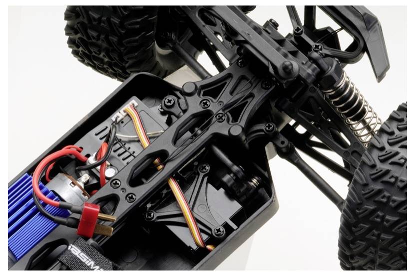 Nahaufnahme der inneren Mechanik eines Fernlenk-Autos, mit komplizierten Verkabelungen, Aufhängungssystem und Motorkomponenten.